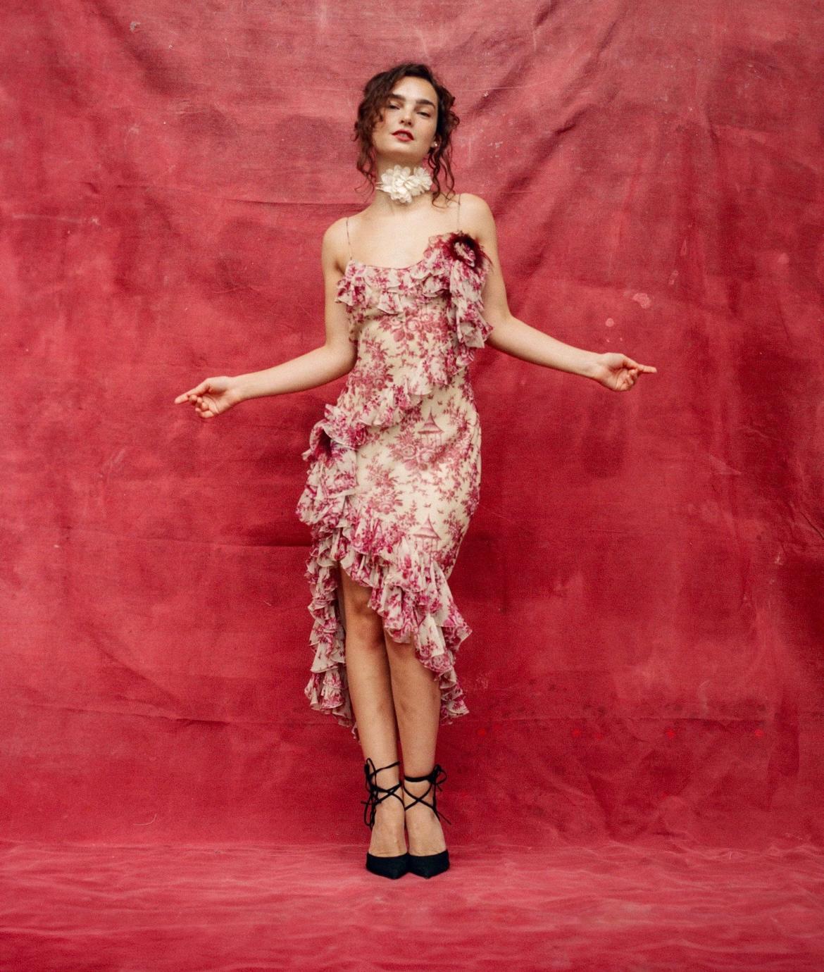 Vintage John Galliano silk Toile de Jouy print dress, with ruffle details and adorned with three dimensional feather trimmed roses. Fall/Winter 2003.

Condition
Very good. The exterior is in excellent overall condition. The lining has slight
