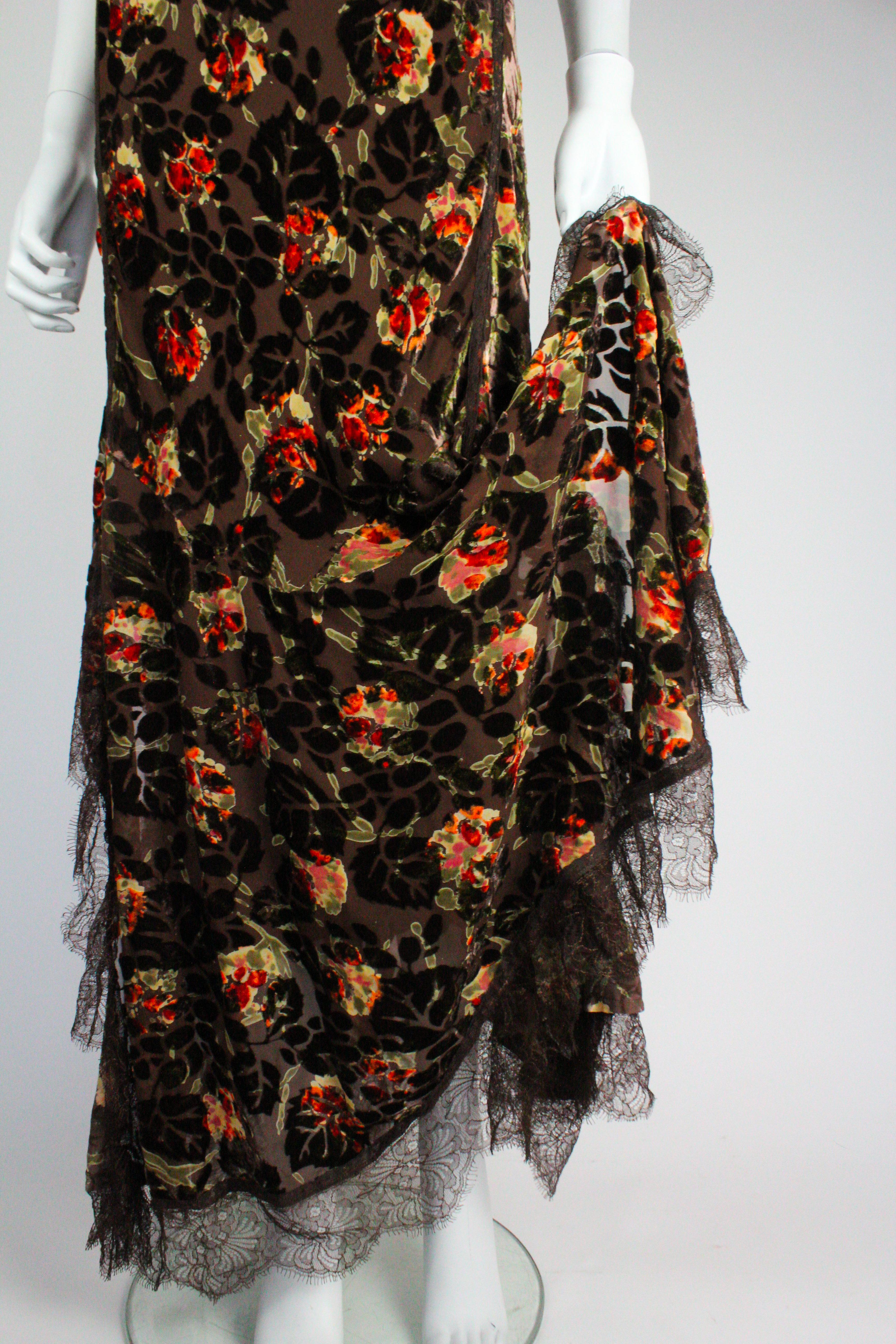 John Galliano dress, with a floral velvet devore pattern, from the Fall/Winter 2005 collection. Beautifully detailed side slits finished with a lace trim, and lined with an inner silk slip. 

Condition
Excellent 

Marked Size
UK 16

Approximate