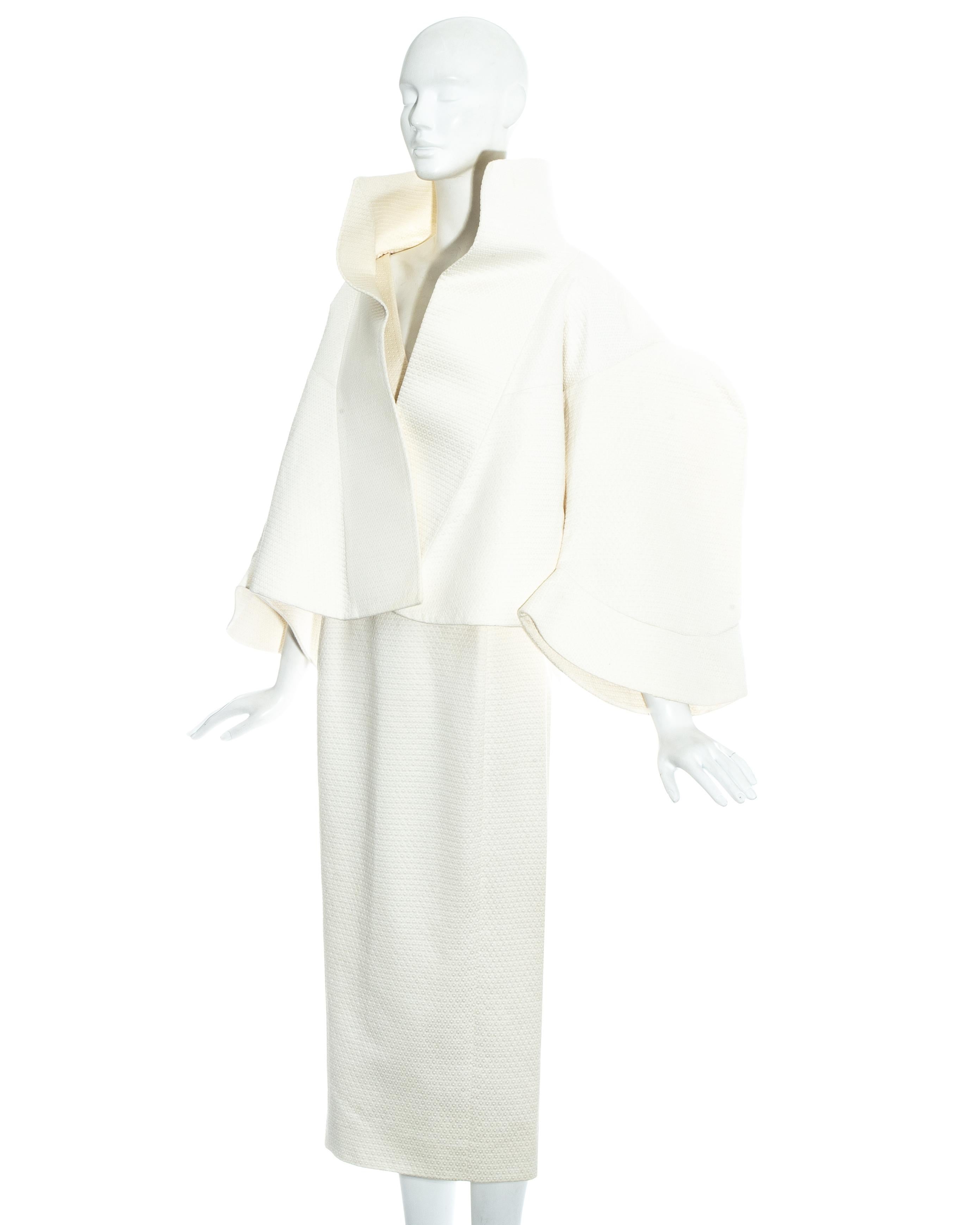 John Galliano; white cotton jacker and dress ensemble. Oversized structured cropped jacket with standing collar and bell sleeves. Fitted mid-length dress with v-neck cleavage. 

Spring-Summer 1995
