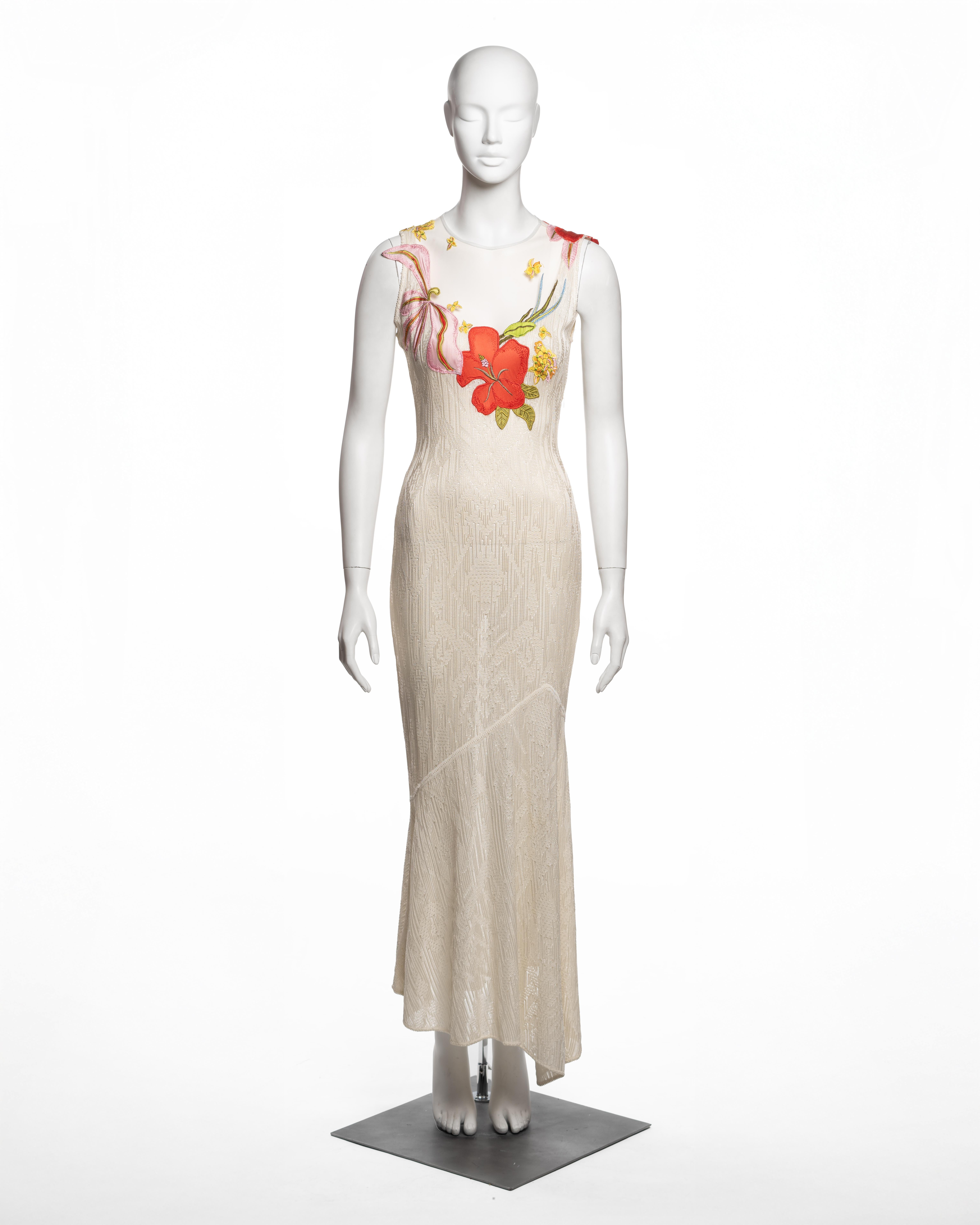 This John Galliano dress from the Fall-Winter 2000 collection is constructed from a fine viscose knit base, featuring a fitted, ankle-length silhouette. The upper bodice is composed of sheer tulle, intricately adorned with satin appliqués in vibrant