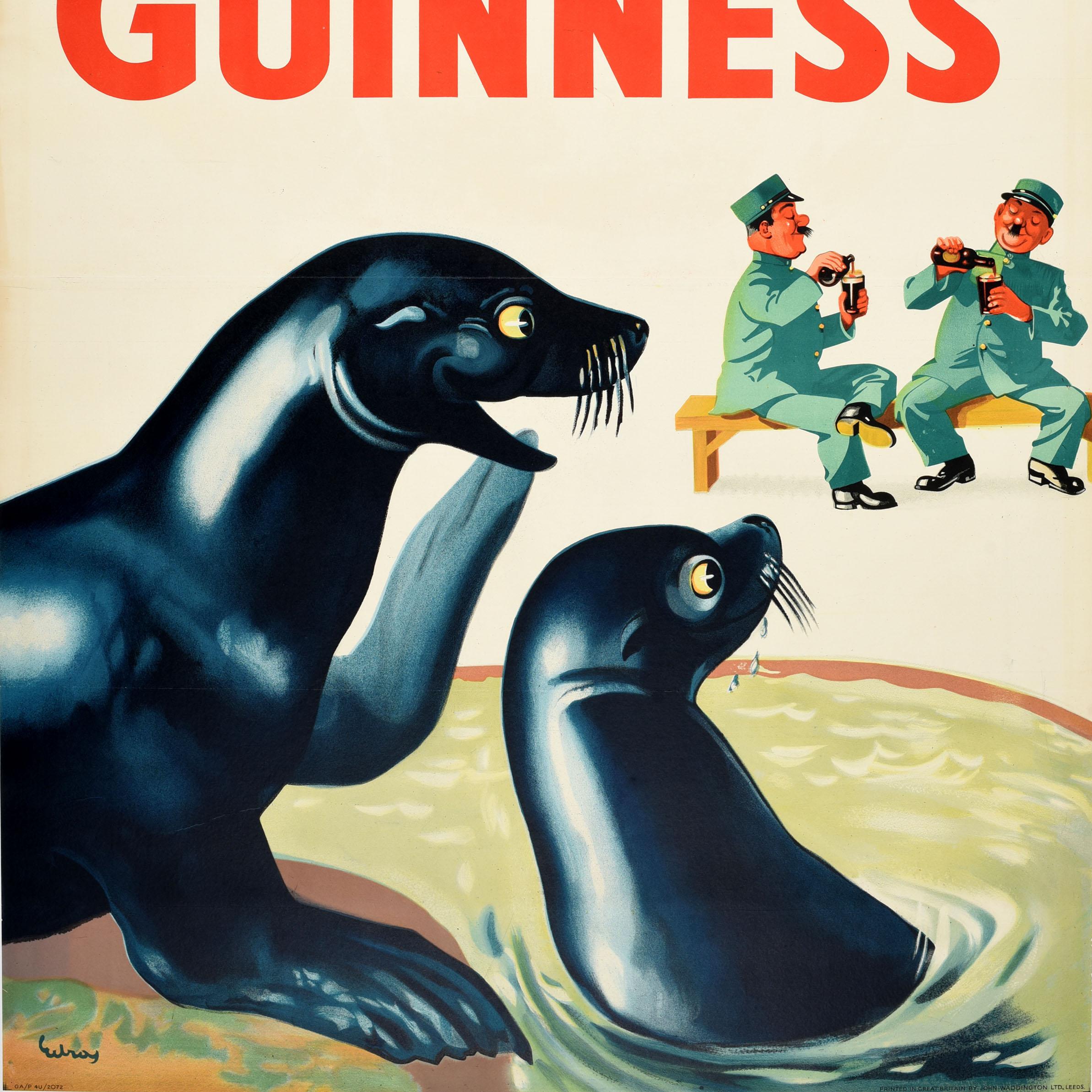 Originales Vintage-Werbeplakat für das Kultgetränk Guinness Irish Stout Bier mit dem Zitat in Rot - Lovely Day For A Guinness - über einem lustigen Bild von lächelnden Robben, die zwei Zoowärter betrachten, die auf einer Bank sitzen und während