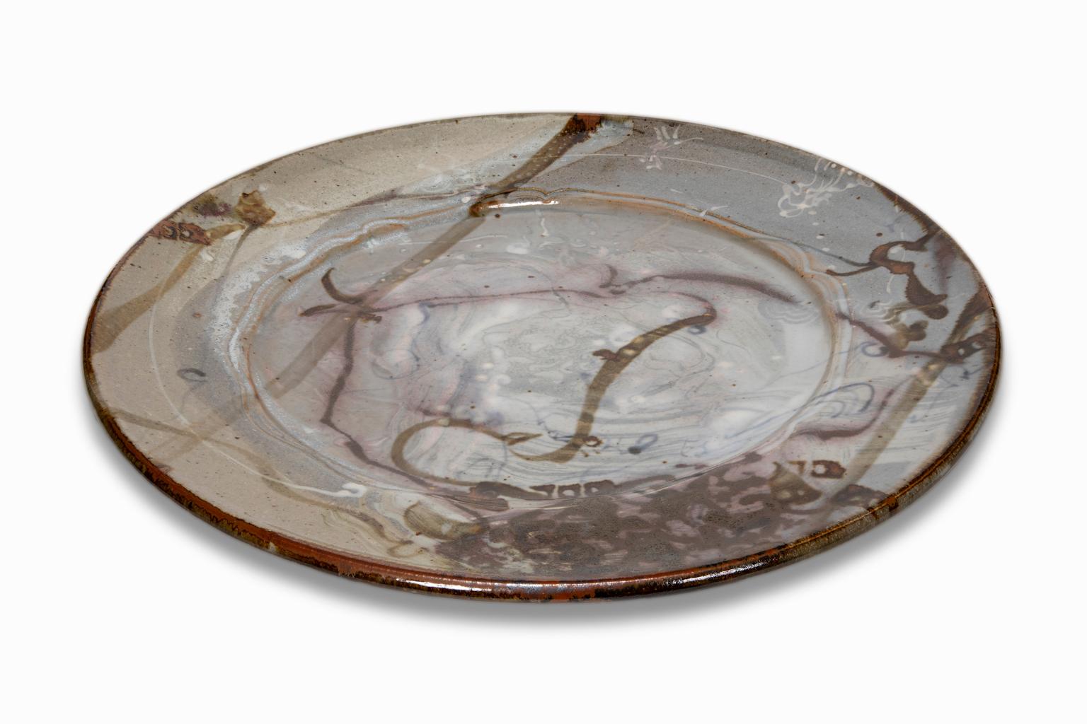 Das Keramik-Ladegerät ist ein Beispiel für die Art von Arbeiten, mit denen John Glick so berühmt wurde. Er war fasziniert von den Effekten des Reduktionsofens, der den Sauerstoffgehalt während des Brennvorgangs senkt und die Flamme dazu veranlasst,