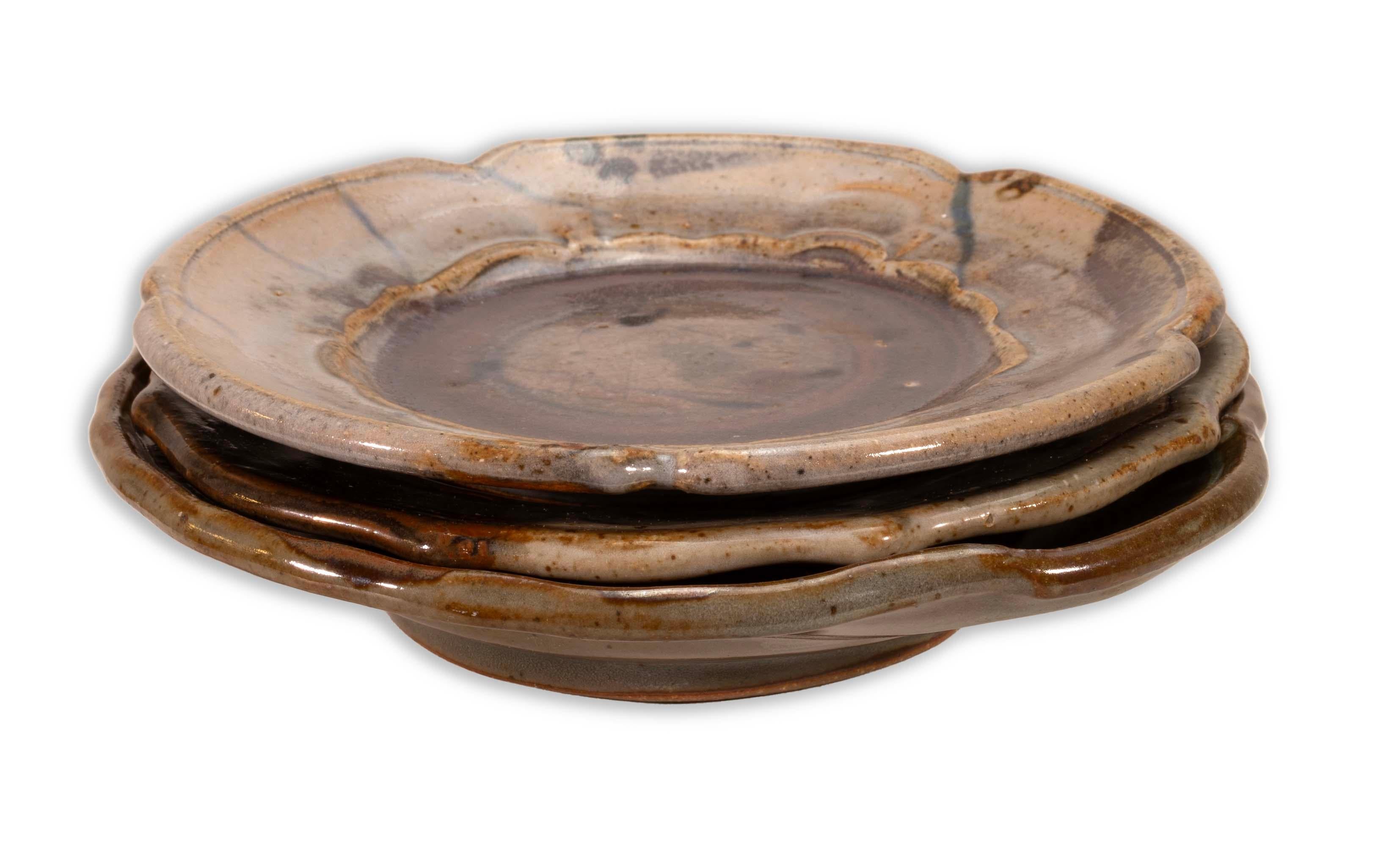 A modernist stoneware glazed ceramic set of 3 small plates by Detroit artist John Glick of Plum Tree Pottery. Circa late 20th century. Glazed in earthtones. Artisisnal yet functional and makes a unique modern statement. From a private collection.
