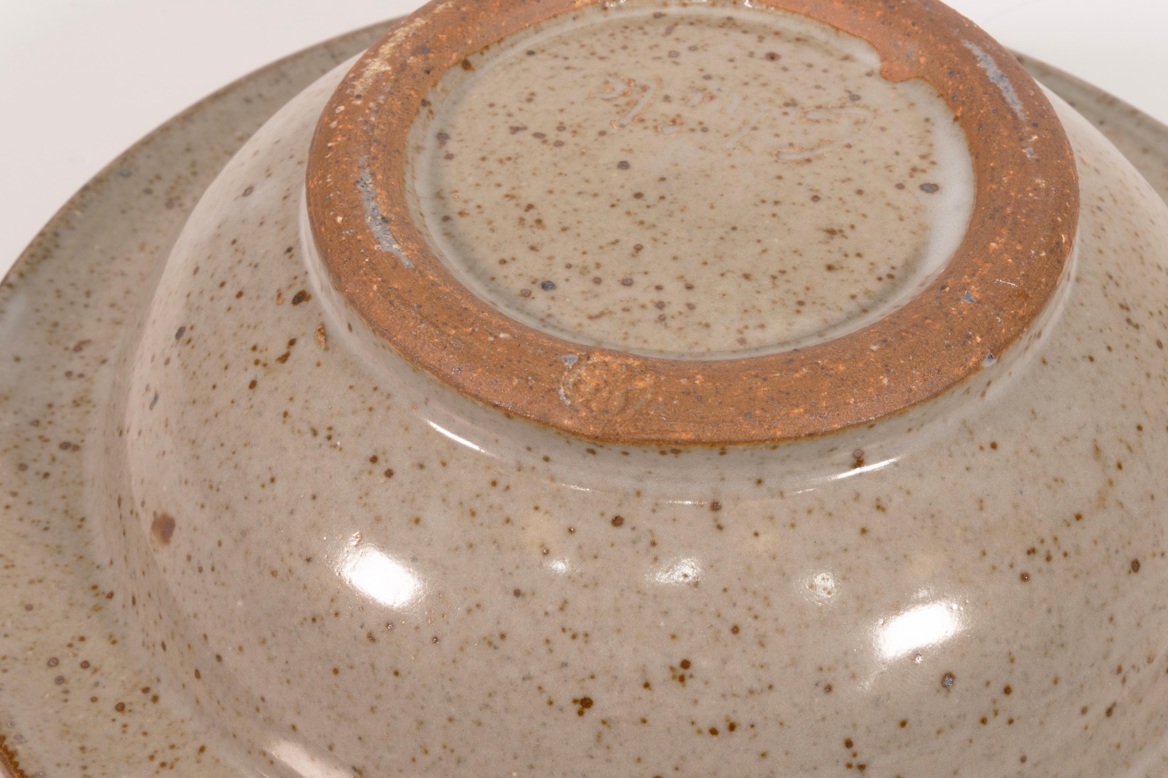 A modernist stoneware glazed ceramic set of 5 bowls by Detroit artist John Glick of Plum Tree Pottery. Circa late 20th century. Glazed in earthtones. Artisisnal yet functional and makes a unique modern statement. From a private collection.  In very