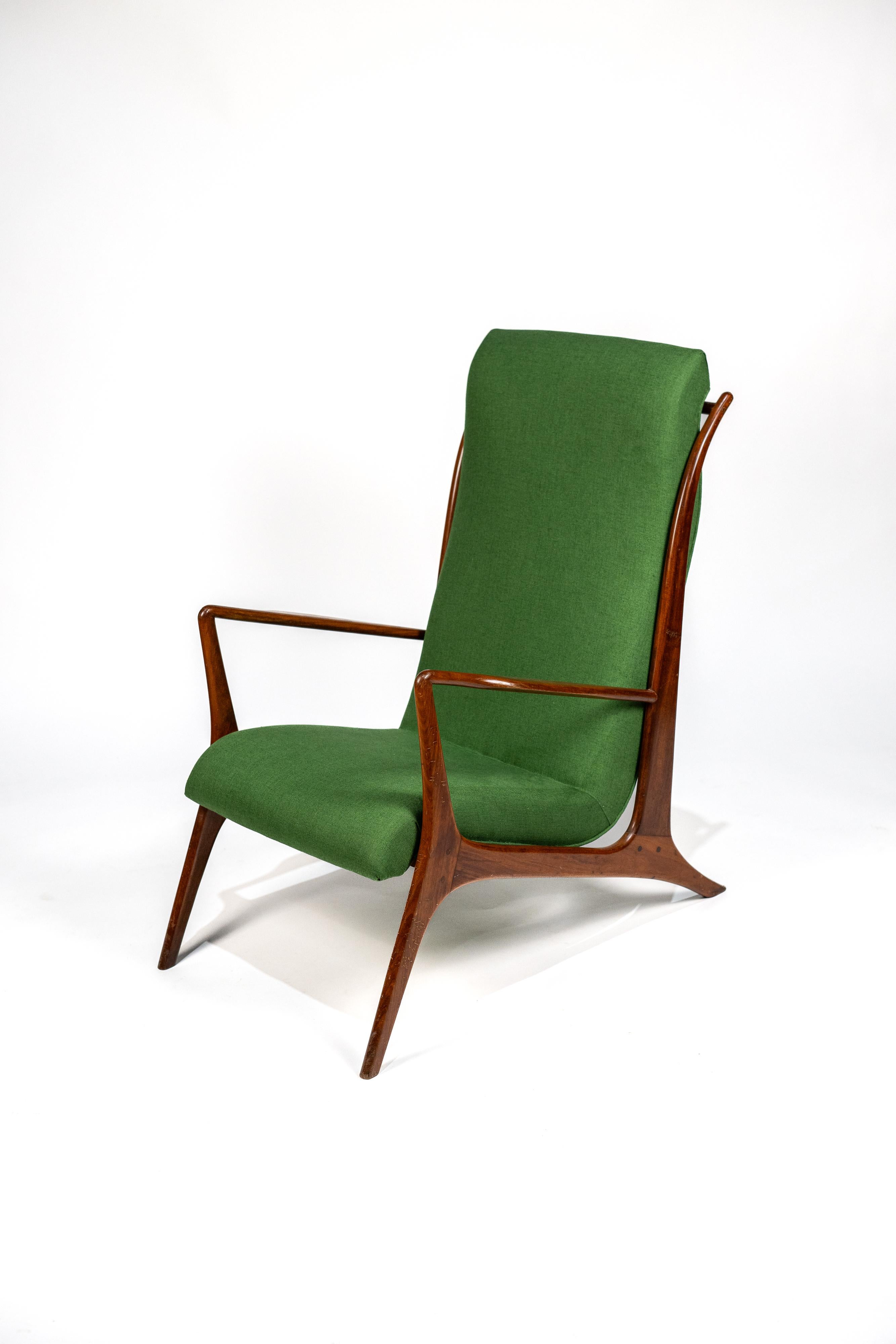 Ce fauteuil de John Graz, datant des années 1960. La pièce se caractérise par un dossier haut légèrement incliné, offrant un confort optimal. Sa structure profilée en caviuna, un bois exotique, confère à l'ensemble une élégance
