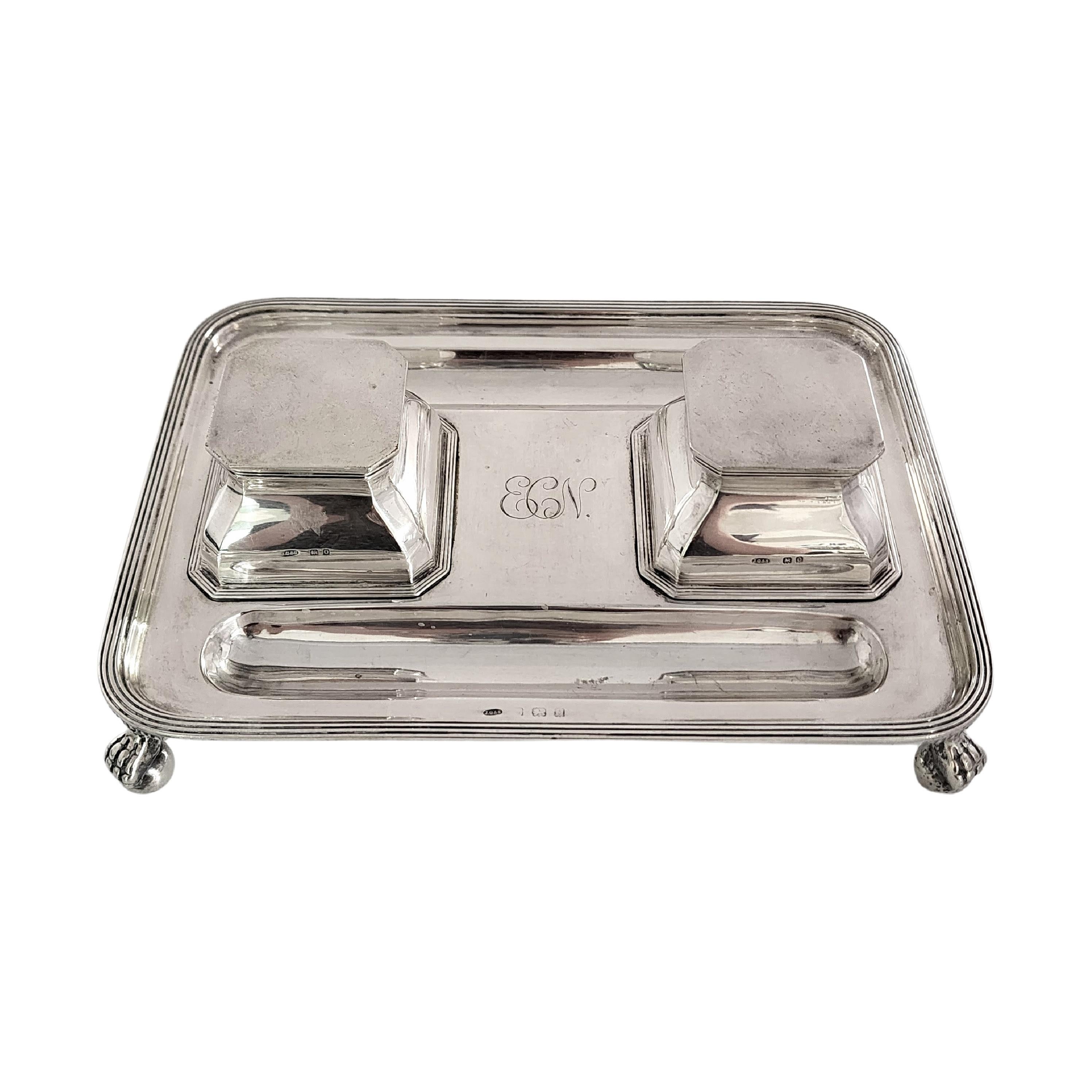 Sterling silver inkwell inkstand desk set with monogram by John Grinsell & Sons of Birmingham, England, circa 1938.

Monogram appears to be ECN

Rectangular footed inkstand desk set featuring 2 inkwell bottles each with a hinged lid and 2 concave