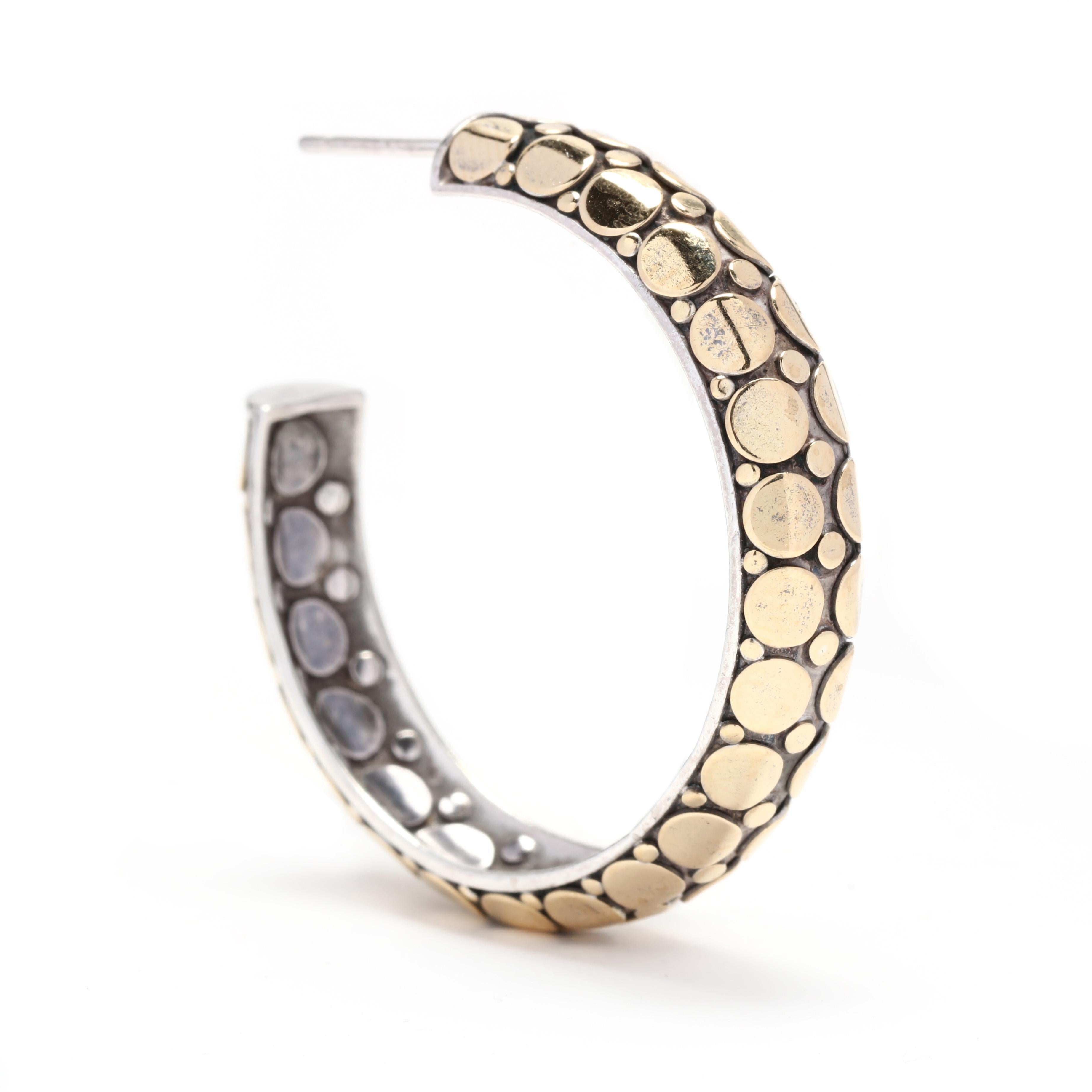 A pair of John Hardy 18 karat yellow gold and sterling silver dot hoop earrings. These earrings features a slightly domed silver hoop with applied gold dot accents with pierced push backs.

Length: 1 5/16 in.

Width: 5/16 in.

Weight: 15.1
