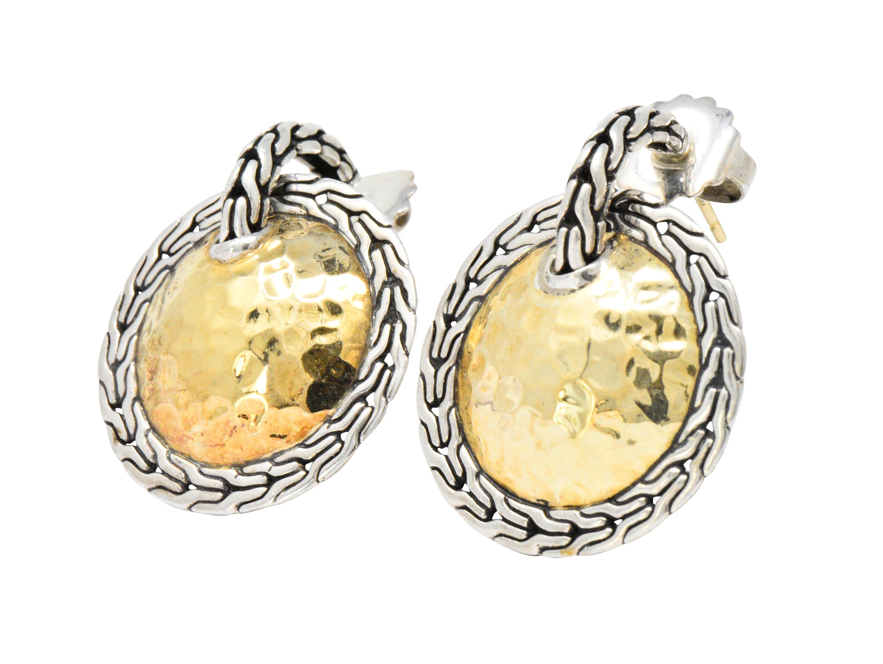 Earrings are designed as a half hoop surmount comprised of a sterling silver classic chain motif

Suspending a large round disk centering a hammered gold dome with a sterling silver classic chain surround

Completed by posts and friction backs

With