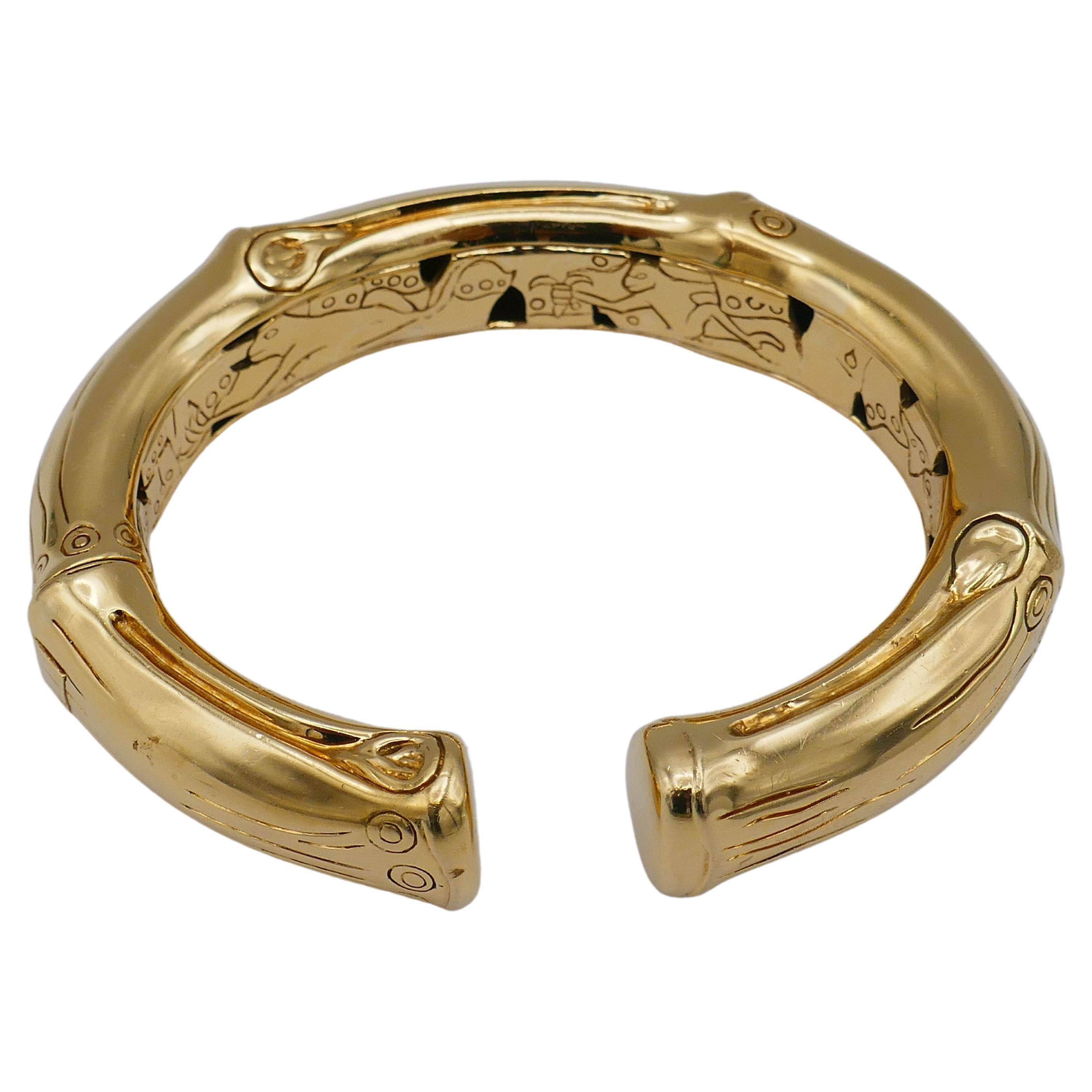 A shiny chunky 18k gold bracelet by John Hardy from the Bamboo collection. 
Handcrafted in Bali, this gold bracelet has an organic bamboo-like shape. 
A signature Hardy's design is applied to the exterior and inner part of the piece. The fine lines