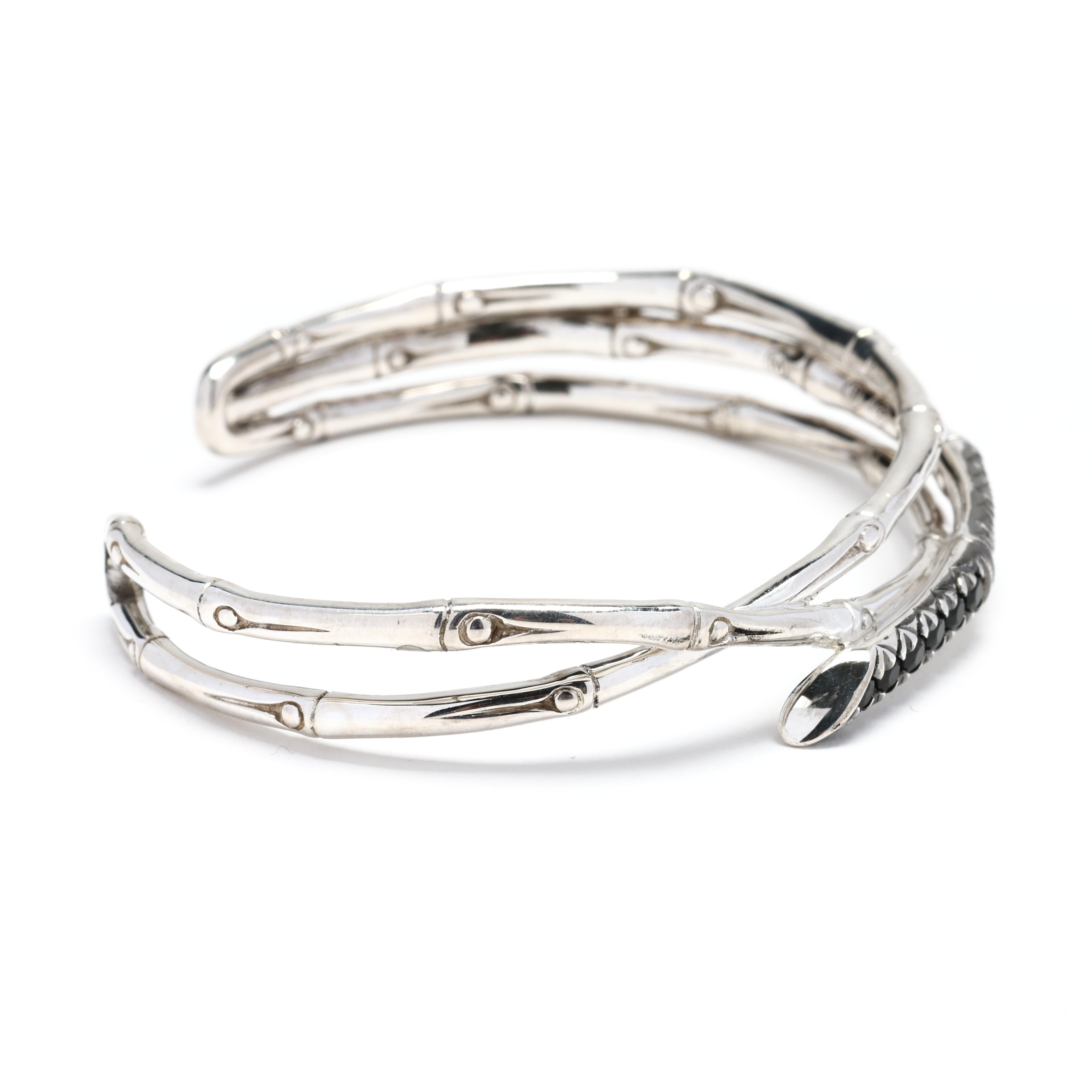 This John Hardy black sapphire bamboo bangle is a stunning accessory that combines elegance with a touch of nature-inspired design. Made from sterling silver, this twisted bracelet features an intricate bamboo pattern along with black sapphire