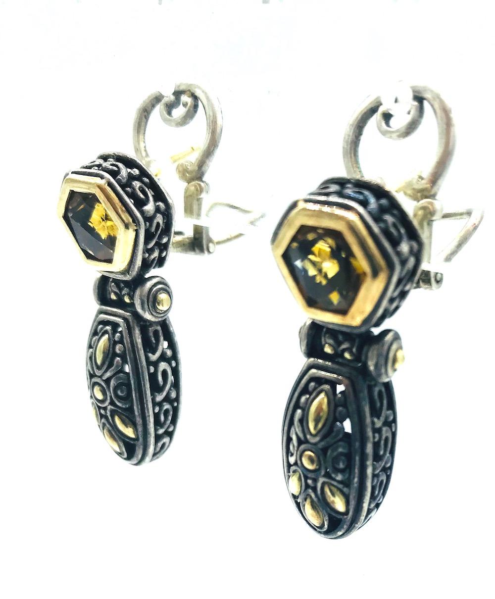 John Hardy, Citrine and 18 Karat Yellow Gold Earrings with Sterling Silver

Octagon shaped, bezel set citrine gemstones set in earring 1.25 x .50 inches wide. 
 Scrolled style with double backing, for omega pierced ears. 
Weight is 19.6