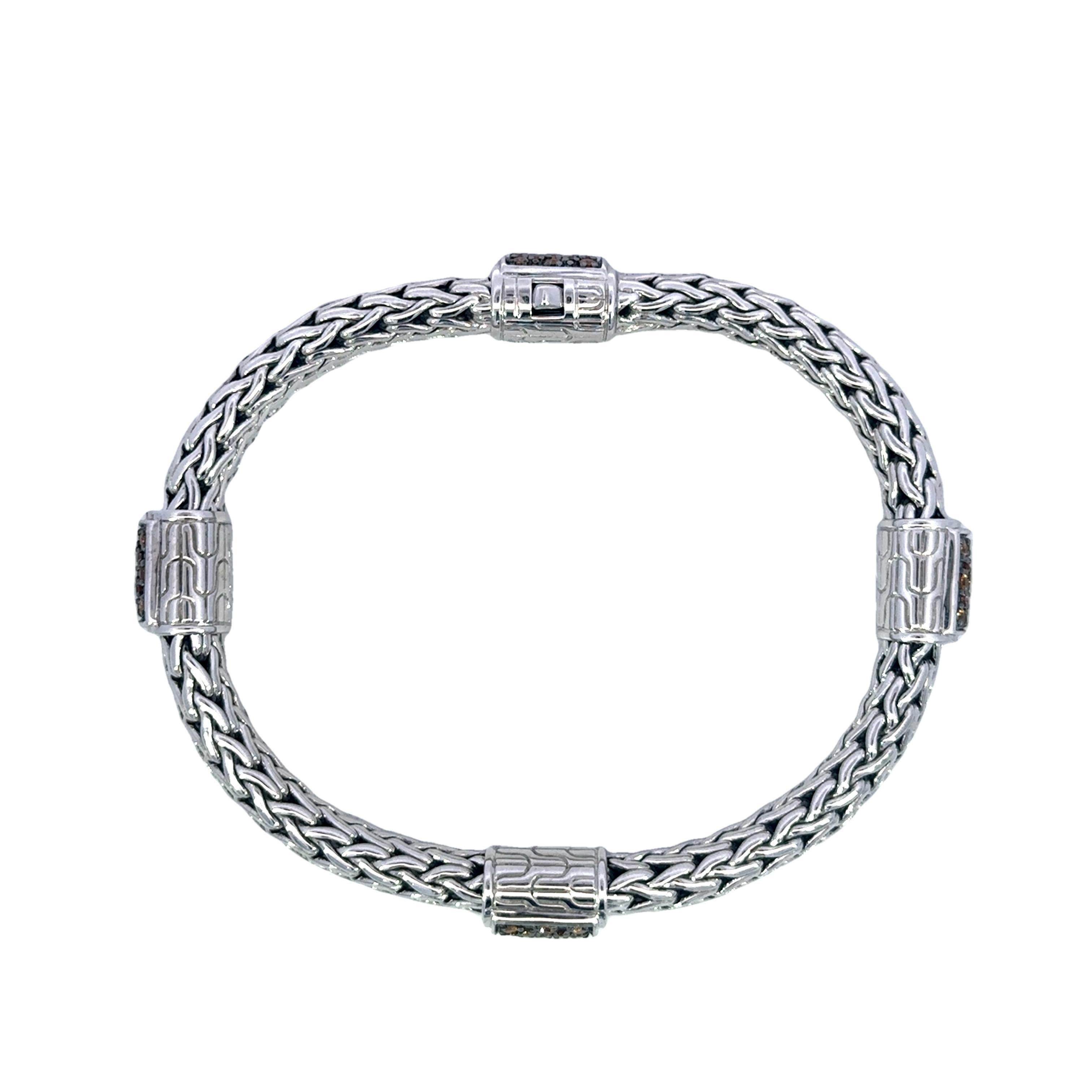 John Hardy Classic Chain Mandarin Garnet Sterling Bracelet 

This sterling silver bracelet showcases a sophisticated woven design, creating a textured and intricate appearance. The centerpiece features round-cut mandarin garnet stones, their vibrant