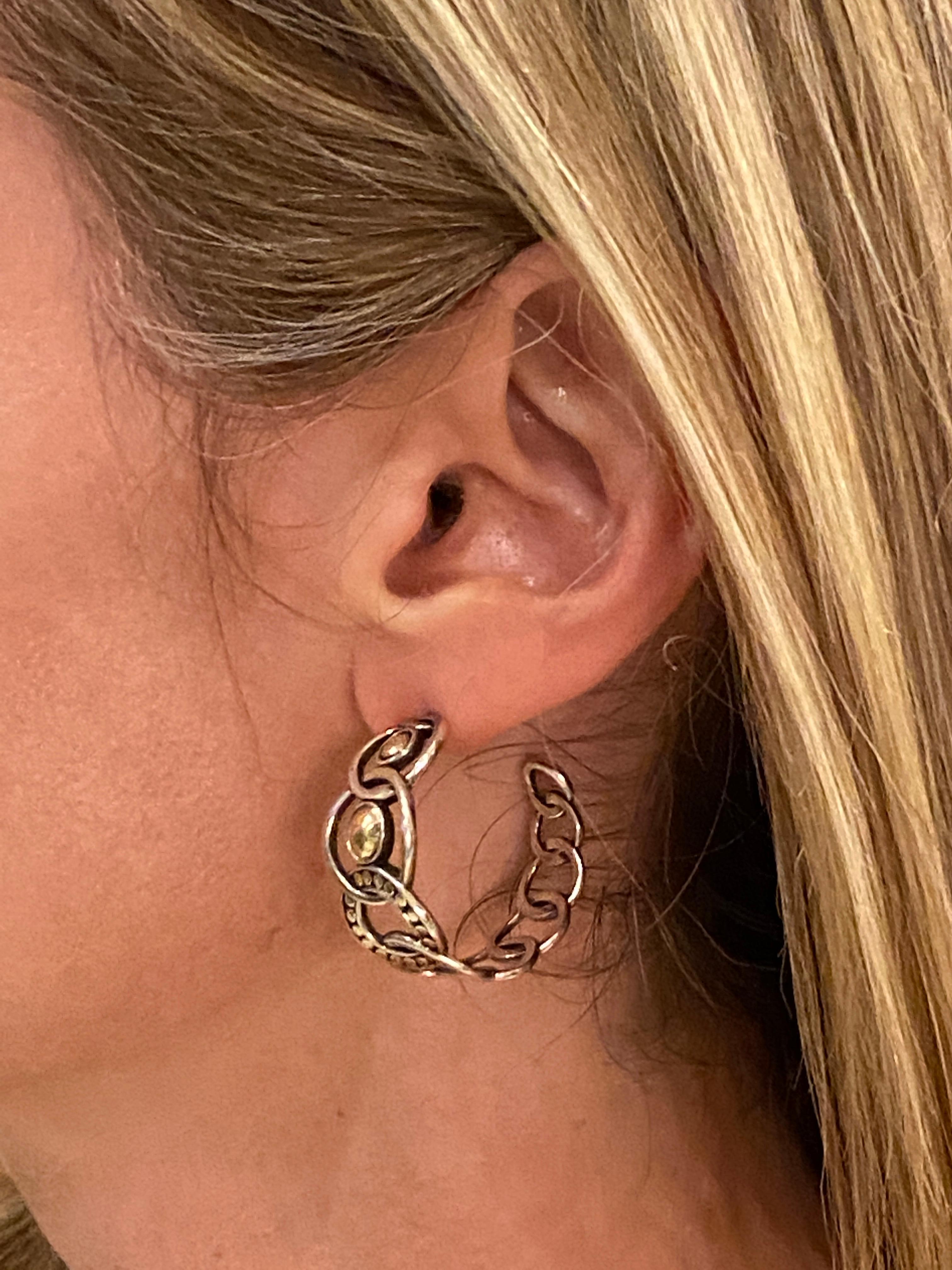 Stylish hoop earrings by designer John Hardy fashioned in sterling silver and 22 karat yellow gold. The hoops are part of the Dot Collection, measure 1.0 inch in diameter, and are signed JH 925 22K. 