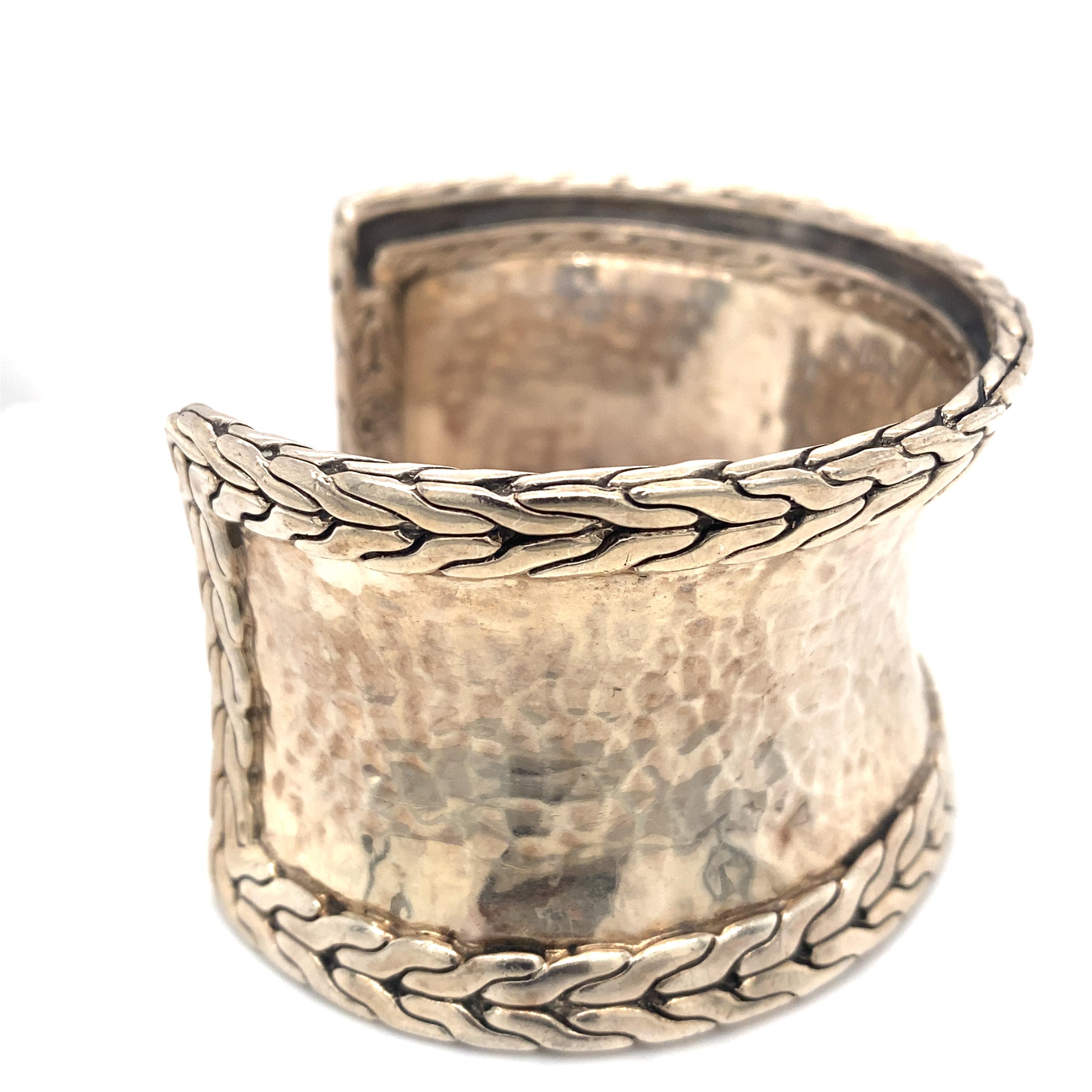 Item Details: This cuff bracelet by John Hardy has a detailed border and a hammered design.

Metal Type: Sterling Silver
Weight: 67.4 grams 