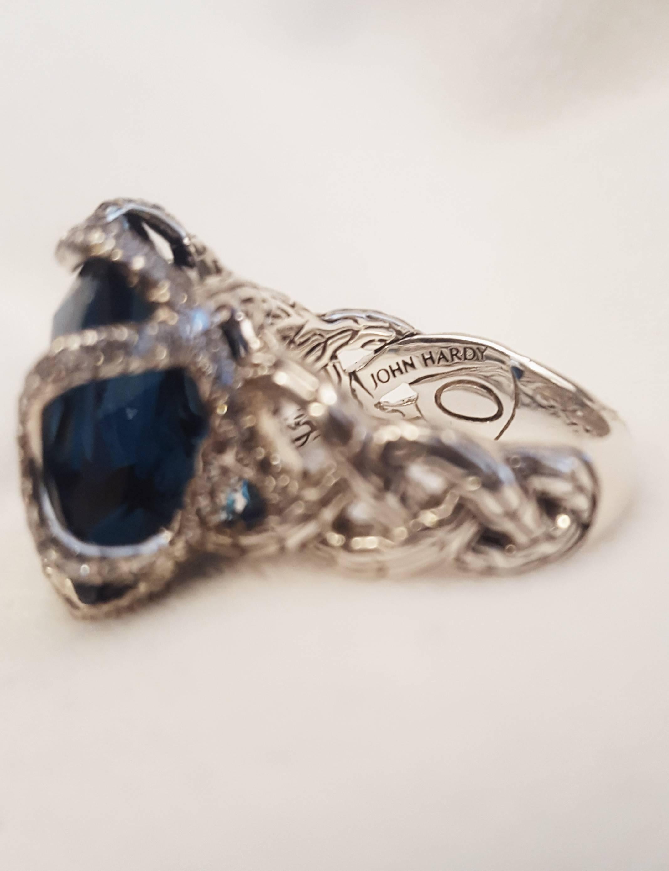 John Hardy has stayed true to the authentic jewelry-making techniques of the Balinese royal courts.  Each one of a kind treasure is meticulously hand crafted with focused attention to detail.  This fabulous ring features a faceted cushion cut blue
