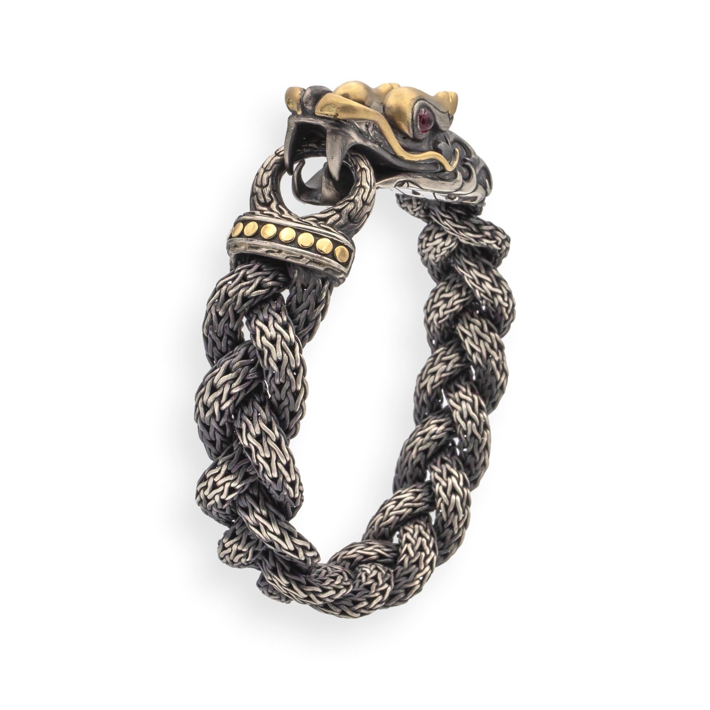 John Hardy Naga Collection bracelet crafted in woven sterling silver with a dark oxidized finish and 18K yellow gold detailing. The centerpiece features a sculpted dragon head with ruby eyes, measuring 16.5 mm at its widest point. The bracelet
