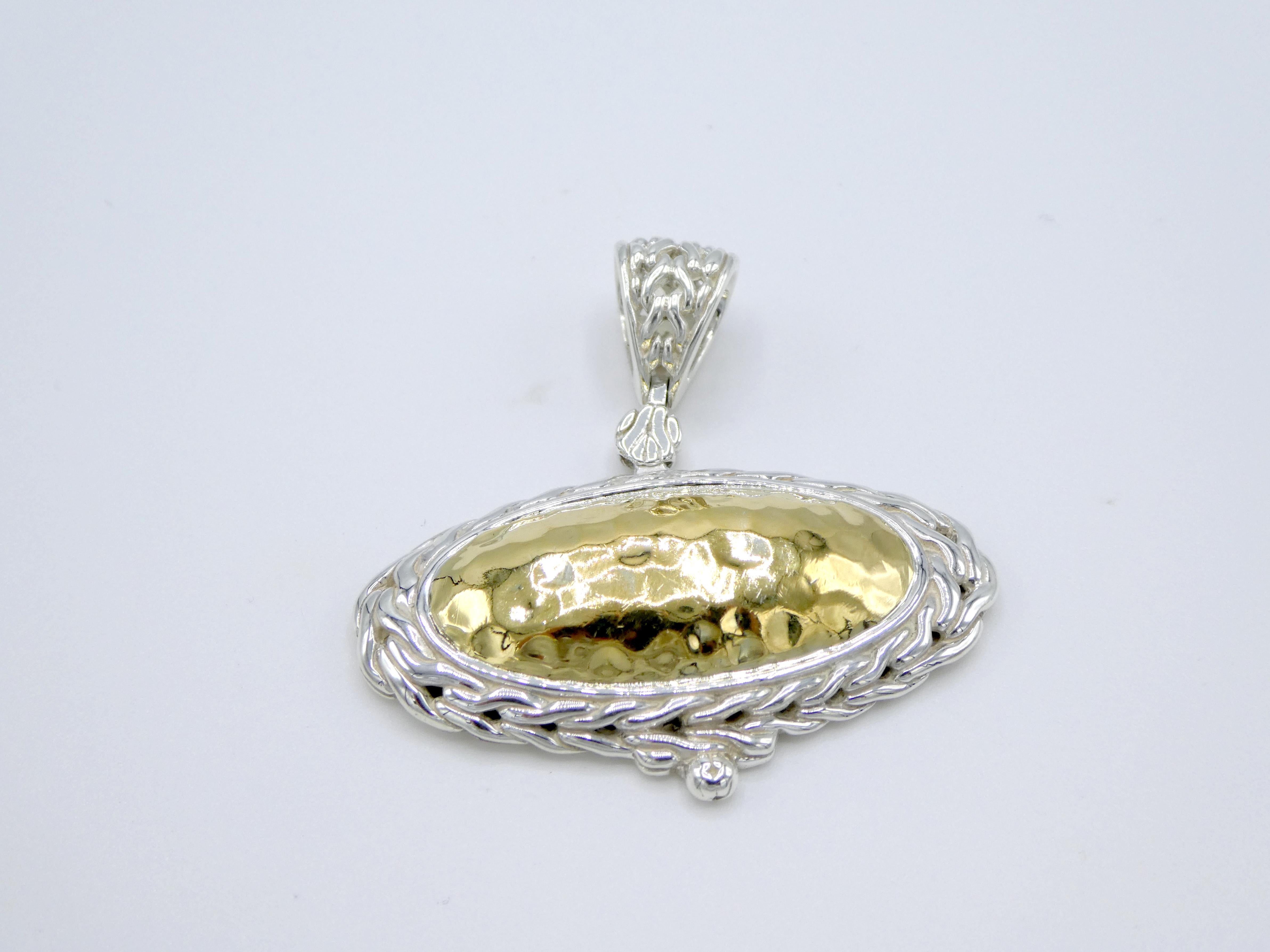 John Hardy Palu Oval Sterling Silver & 22K Gold Hammered Pendant

Metal: Sterling silver & 22k yellow gold
Weight: 14.1 grams
Length (including bale) Approx. 1.5 inches
Width: Approx. 1.6 inches
Signed: 22k 925 JH hallmark
Pendant only