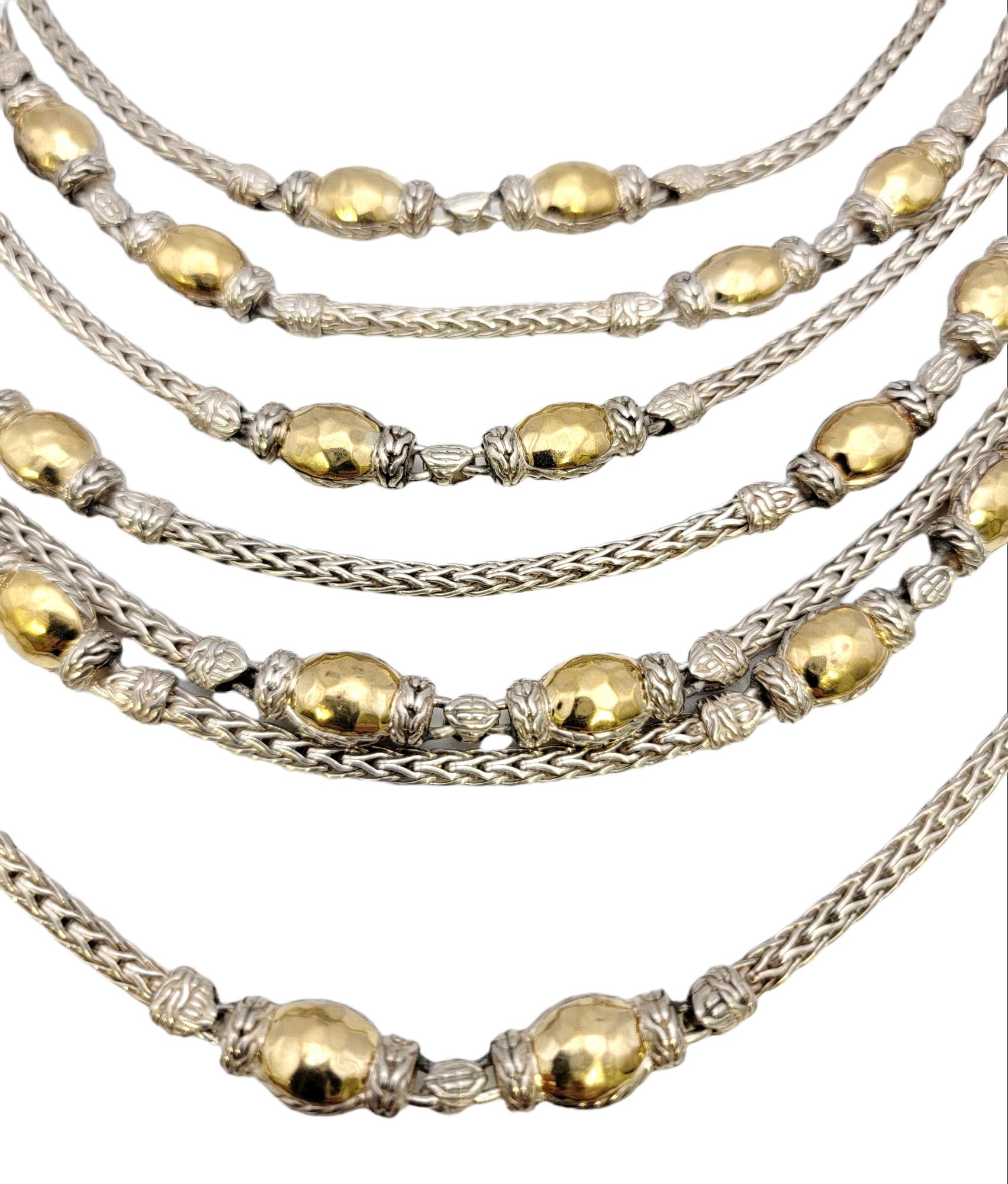 Incredible statement piece by designer, John Hardy. Part of the Palu collection, this seven strand necklace  features a series of sterling silver wheat chains, graduated in length, and embellished with hammered 22 karat yellow gold beaded stations