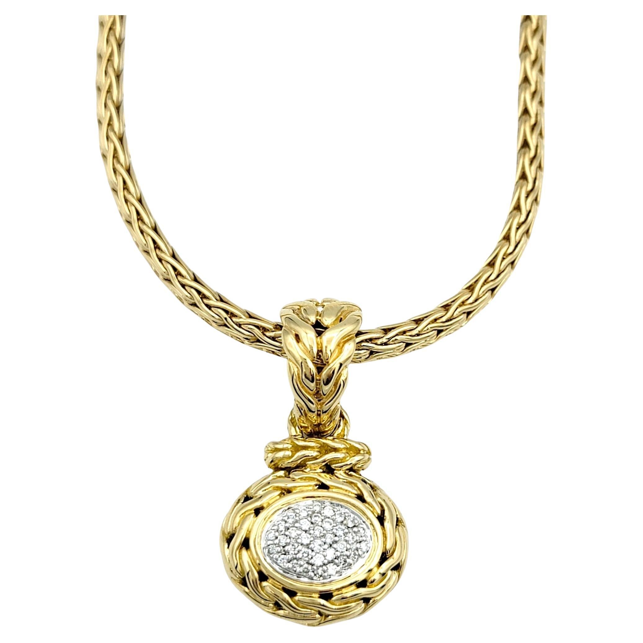 This beautiful John Hardy pavé diamond pendant necklace in 18 karat yellow gold is a striking piece that seamlessly blends luxury with artisanal craftsmanship. At the heart of the necklace lies an exquisite oval pendant adorned with pave diamonds,