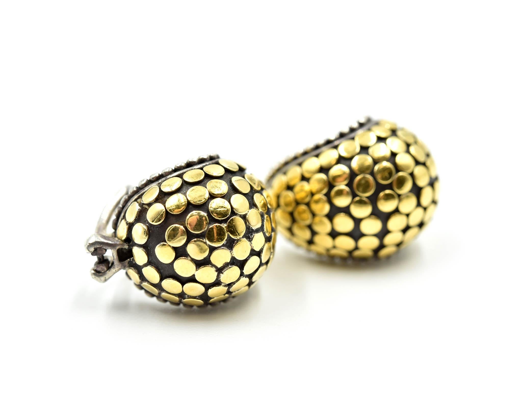 This is a classic John Hardy design with a dot collection! This pair of sterling silver John Hardy dot earrings is crafted with 18k yellow gold dots. Each earring measures 16.17mm in length and 14.36mm in width. Each earring is set with omega backs
