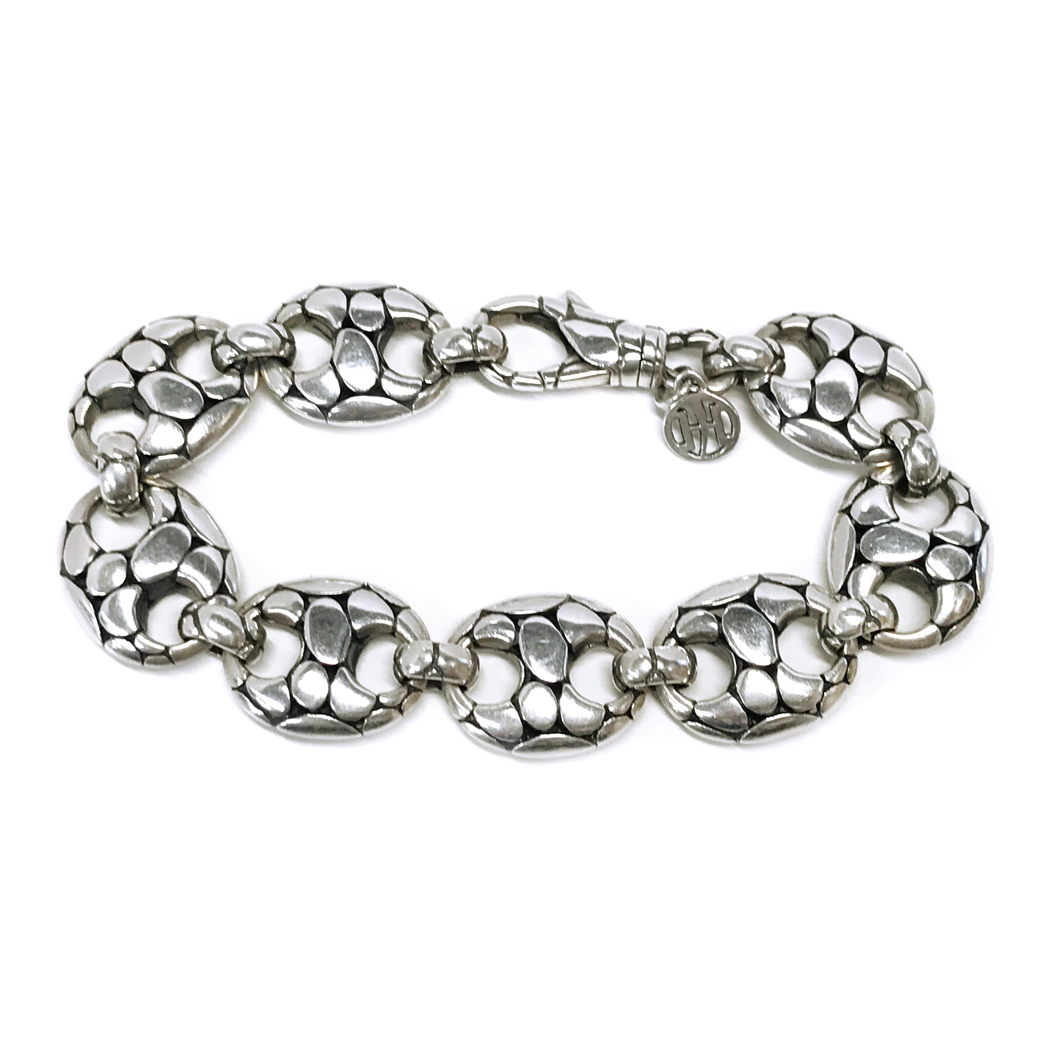 John Hardy Sterling Silver Kali Pebble Bracelet. The bracelet has nine oval links and a lobster clasp closure with the John Hardy logo detail. The bracelet measures approximately 7