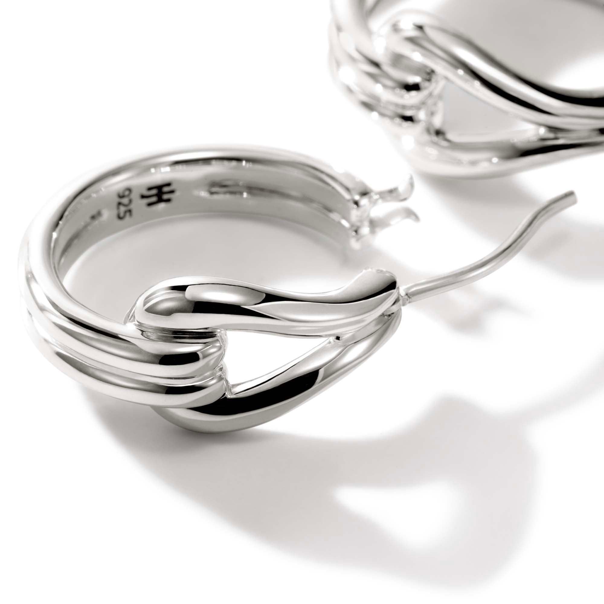 The John Hardy Surf Collection features modern, sculpted lines that emulate ocean waves. Crafted in sterling silver, these Surf Medium Hoop Earrings feature a high-polish finish and a rippled silhouette. These earrings measure 18.5mm in length and