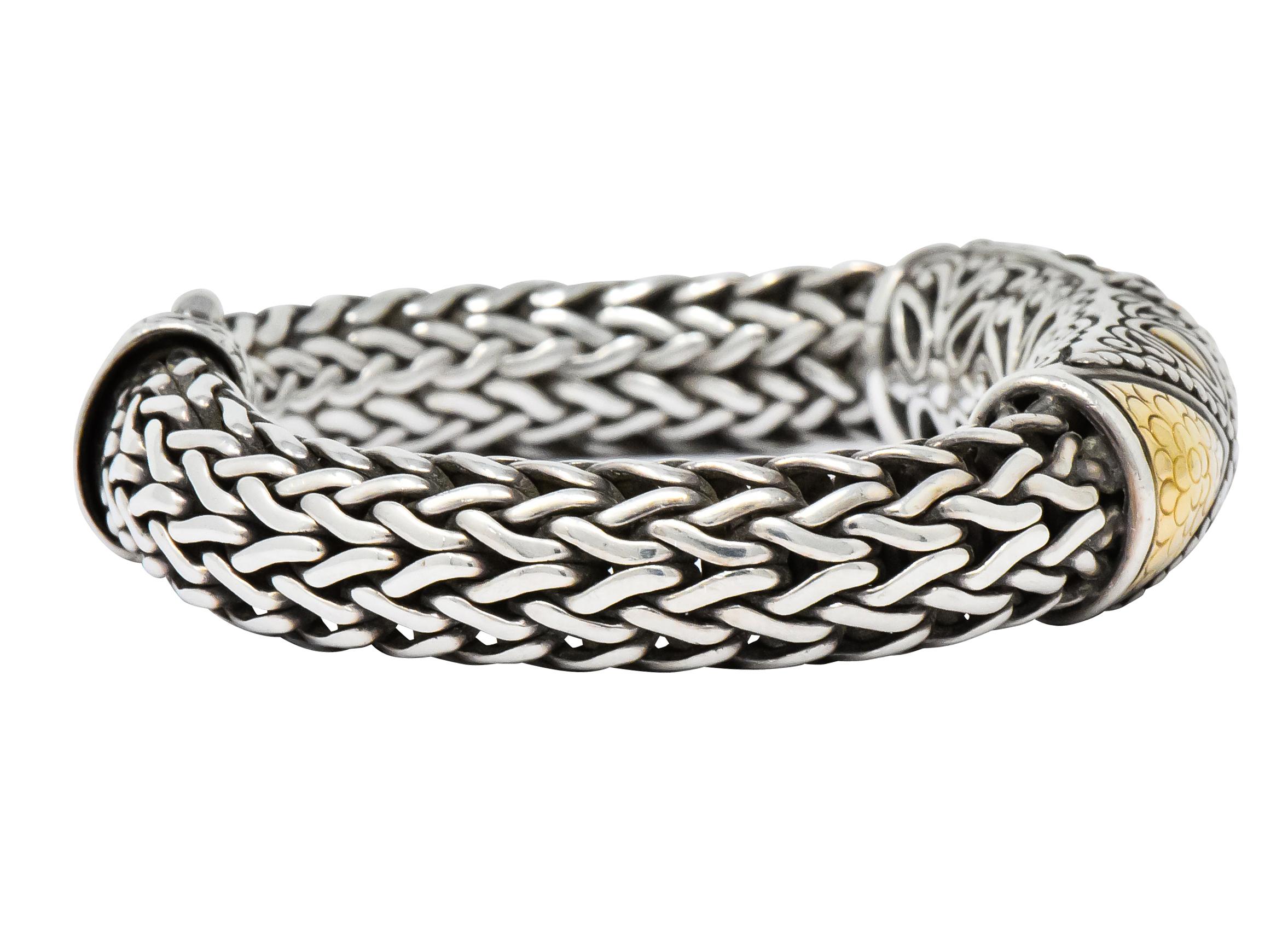 Thick sterling silver woven bracelet with large, front facing two-tone station

Station centers three sections of polished gold with a stylized dot pattern surrounded by regal motifs and an ornately pierced back

Completed by decorative double