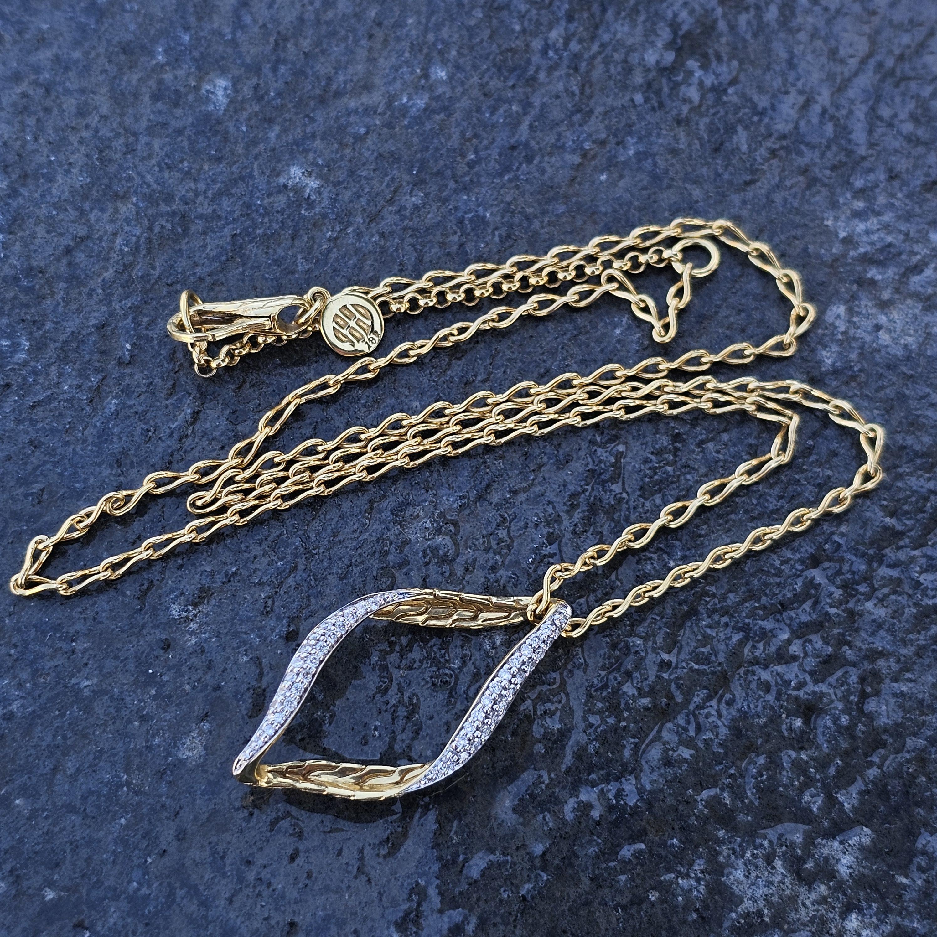 Voici un superbe collier pendentif John Hardy en or jaune 18 carats. Le design présente une élégante marquise ouverte, ornée de diamants blancs étincelants. Les détails complexes de l'or ajoutent une touche de sophistication qui rehausse l'allure