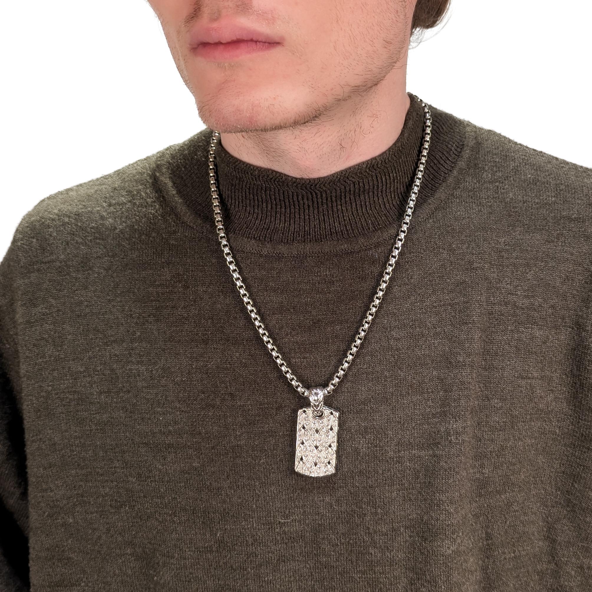 Un bel ciondolo a forma di medaglietta per cani.

Di John Hardy.

In argento sterling. 

Con zaffiri bianchi rotondi incastonati in un motivo a cavo sul davanti e un serpente/drago (Naga) intorno a una spada sul retro. 

Sul retro è presente il