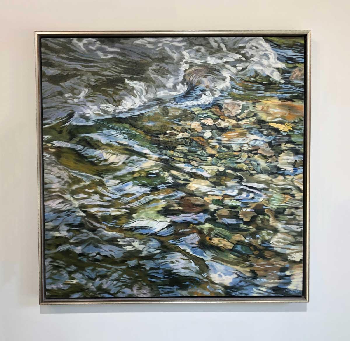 This original realistic oil painting on linen is highly detailed, close up view of river water running over small, colorful rocks. The artist seamlessly depicts the visible shapes, textures, and earthy colors of the rocks beneath the water, which