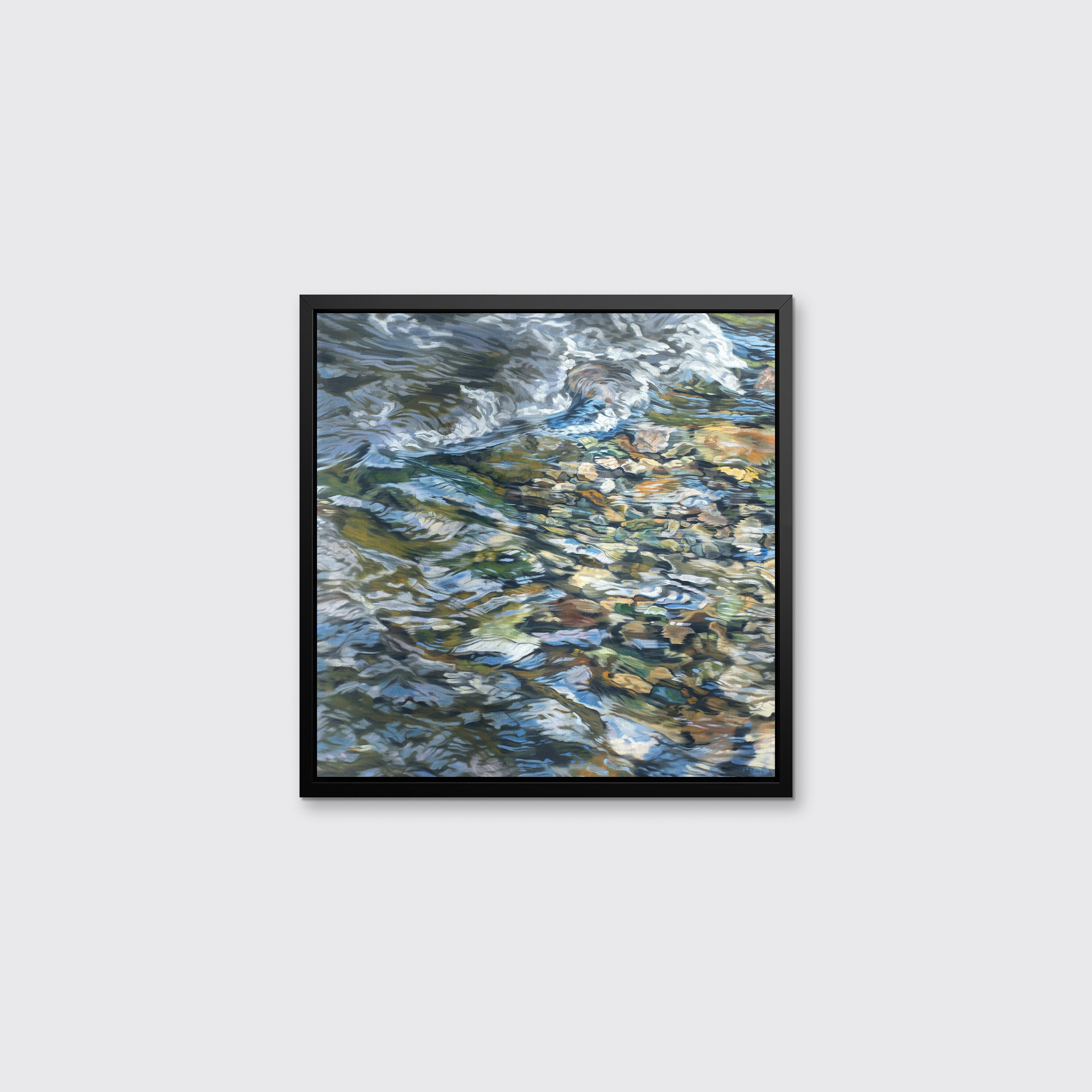 This realistic limited edition print captures a highly detailed, close up view of river water running over small, colorful rocks. Above the shapes, textures, and earthy colors of the rocks, the water reflects the light above it. Filled with abstract