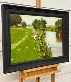 Homme pêchant avec des enfants jouant au bord d'une rivière dans la campagne anglaise