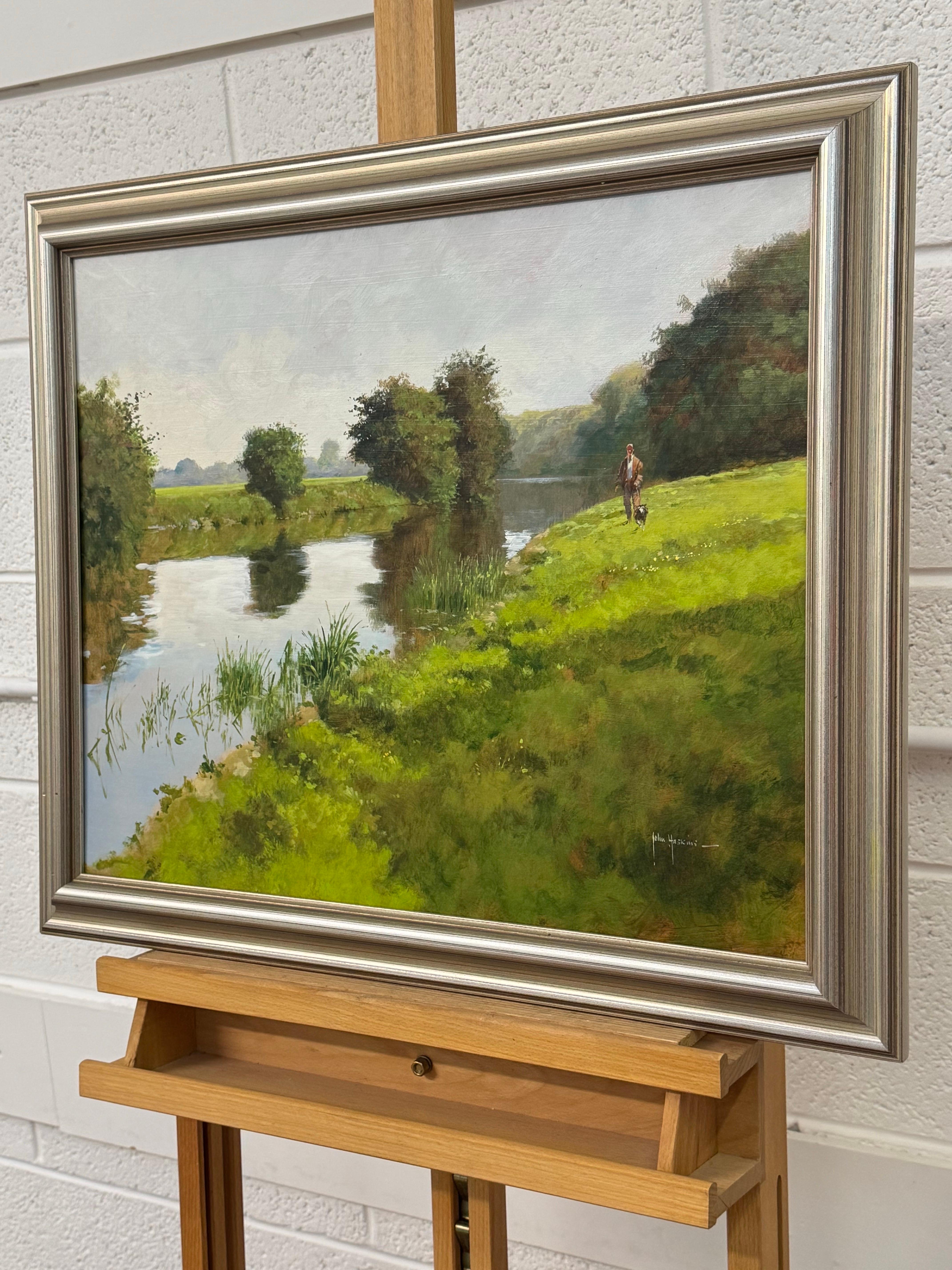 Hombre paseando al perro junto a un río en la exuberante campiña inglesa en venta 9