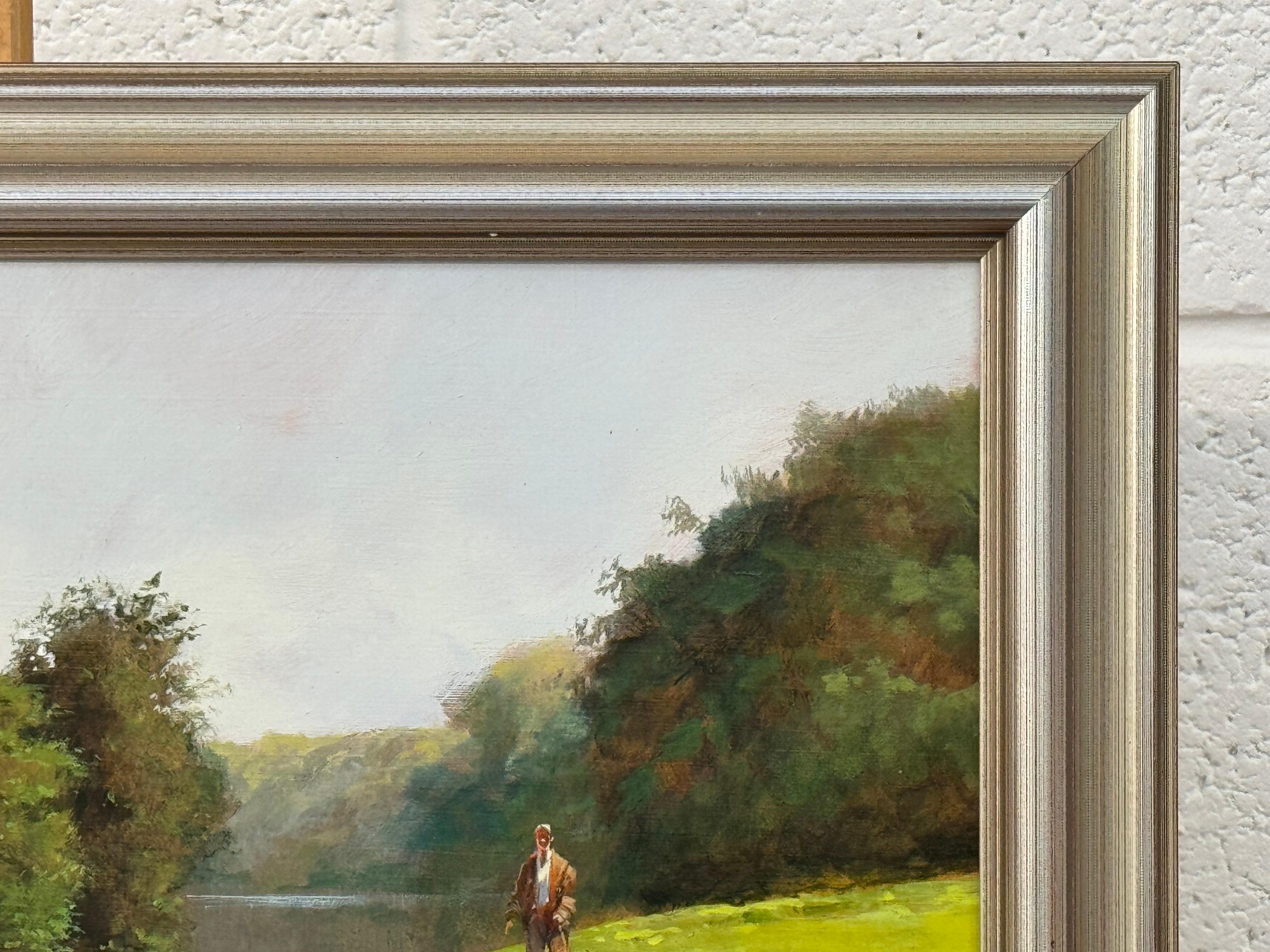 Hombre paseando al perro junto a un río en la exuberante campiña inglesa en venta 2