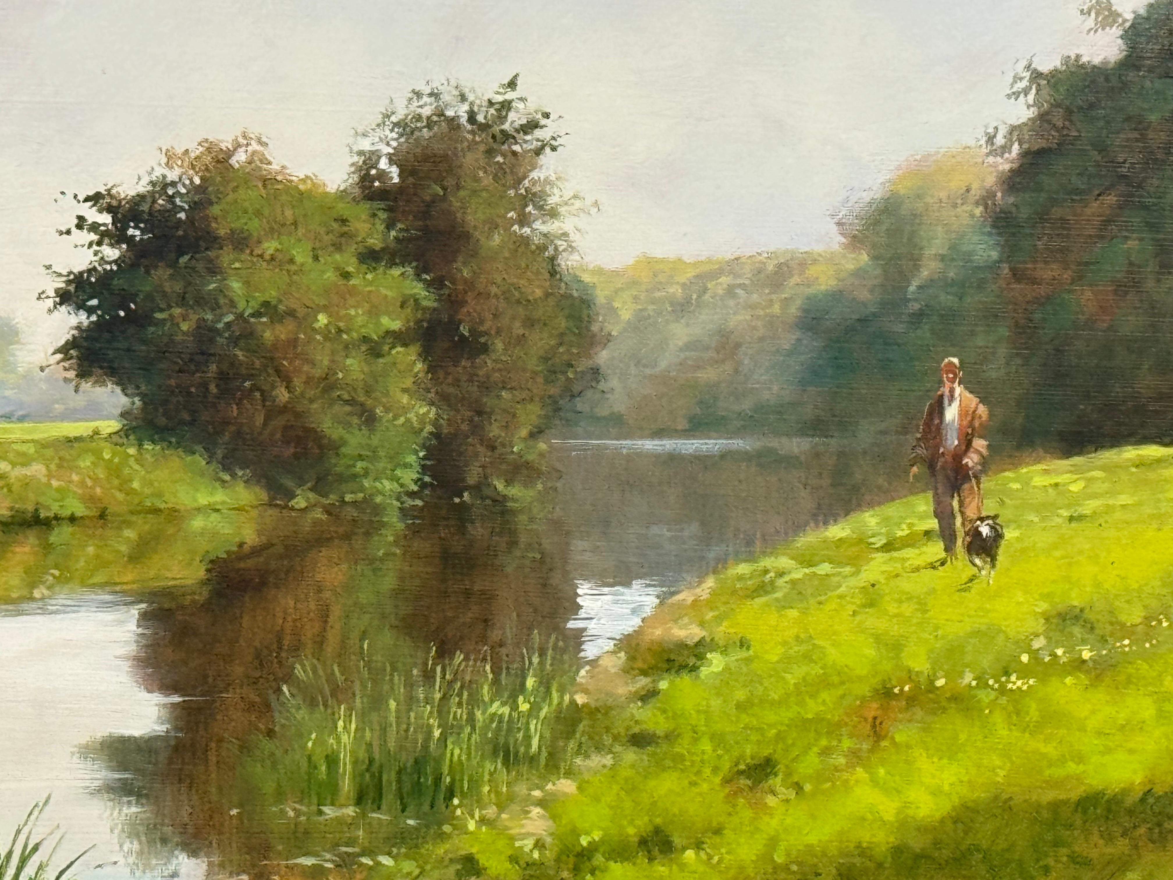 Hombre paseando al perro junto a un río en la exuberante campiña inglesa en venta 4
