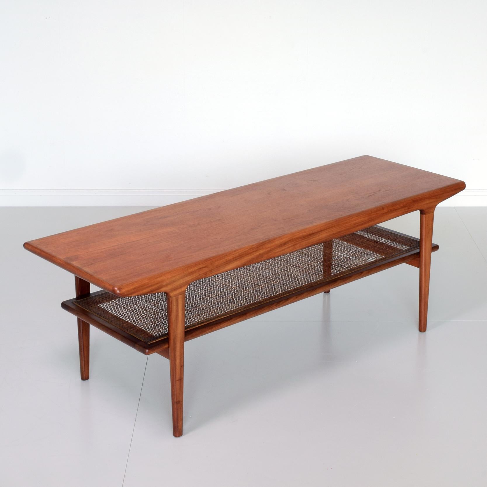 John Herbert (designer)
A. Younger Ltd, UK (manufacturer)

'Fonseca' low table, circa 1958.
Beautiful mid-century two-tier coffee table. Teak with cane/rattan shelf.

Condition: vey good condition. Teak top and frame has been lightly re-waxed.