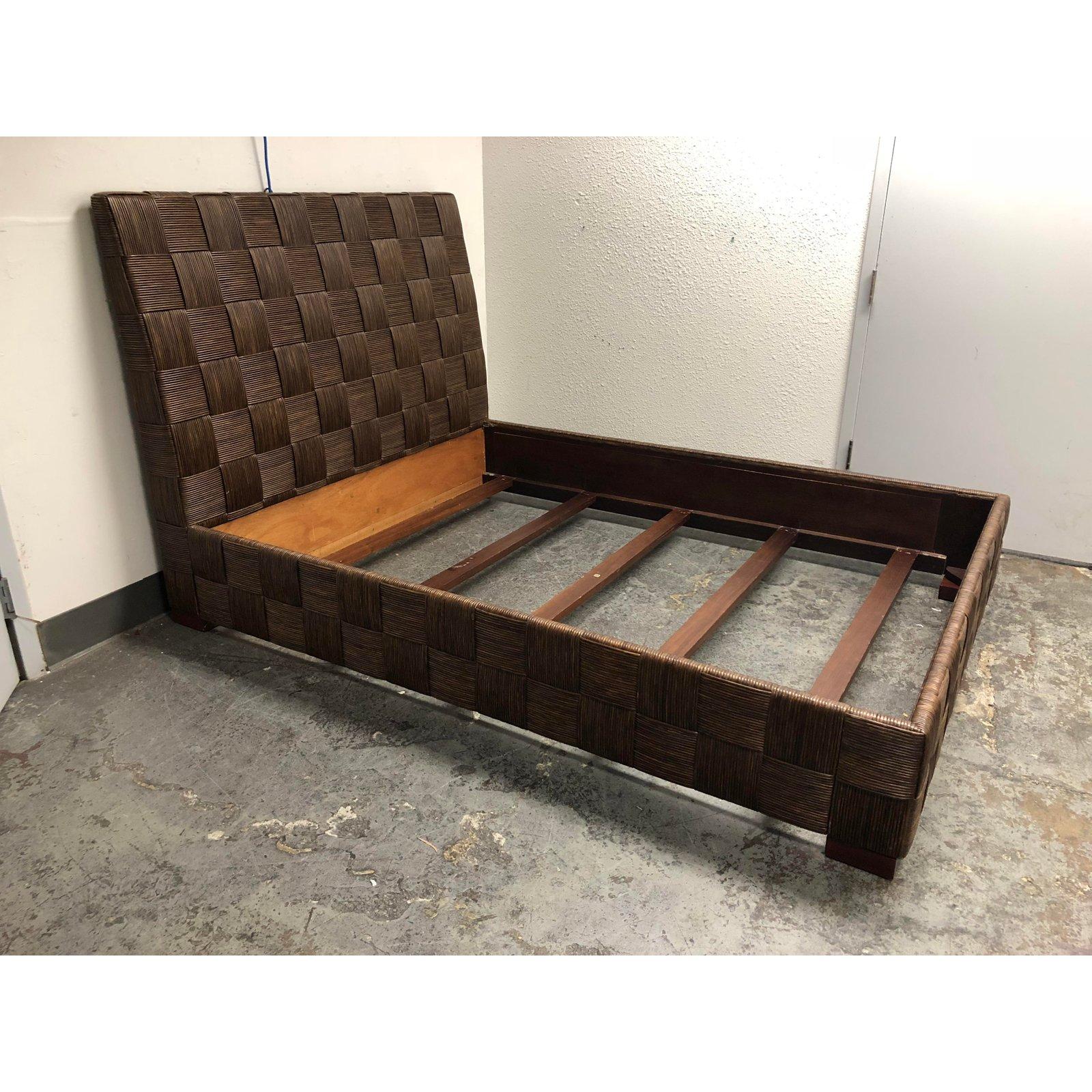 A queen-size bed frame by Donghia. From the Block Island collection designed by John Hutton in 1995. Hutton was the firm design director from 1978-1998. A stout mahogany frame construction veneered in block patterned rush style wicker. The stain is