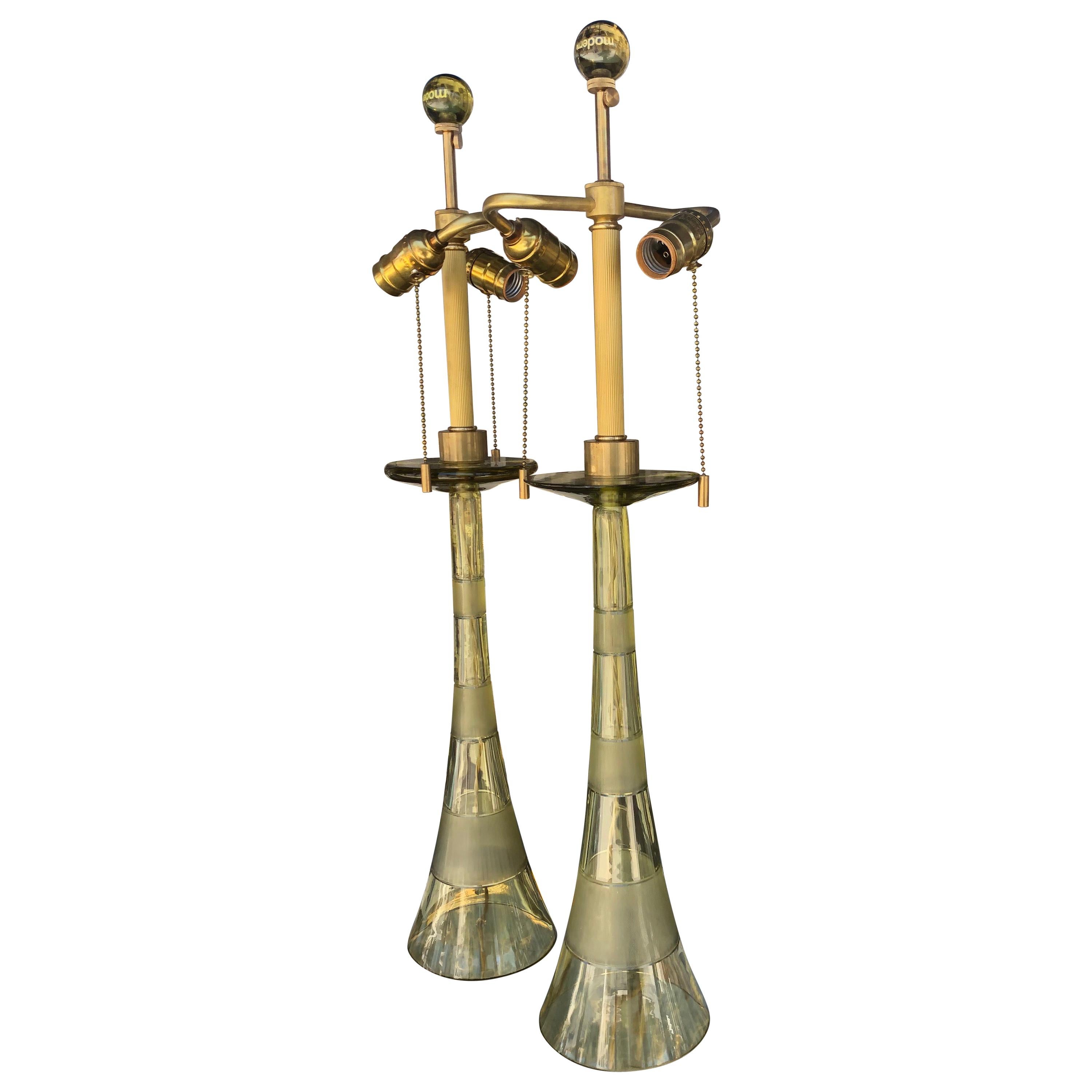 These beautiful pair of lamps were designed by John Hutton for Donghia in the 1980s. They are in a very rare citrine color glass and were made in Italy. No chips. Each lamp has brass fittings with double bulb sockets. Original silk cord wiring. One