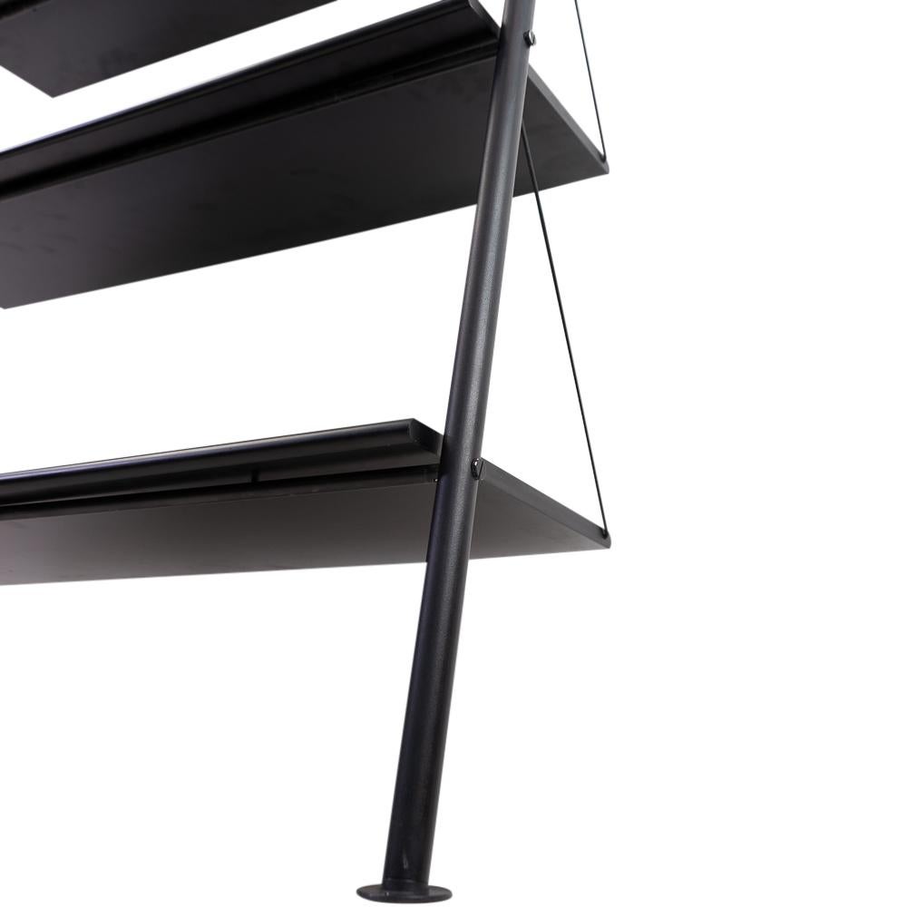 Bookshelf designed by Philippe Starck in 1977, produced by Disform.

The “John Ild” shelving unit consists of 5 black lacquered wooden shelves, along black metal tube uprights. The whole structure rests against the wall on its own weight, without