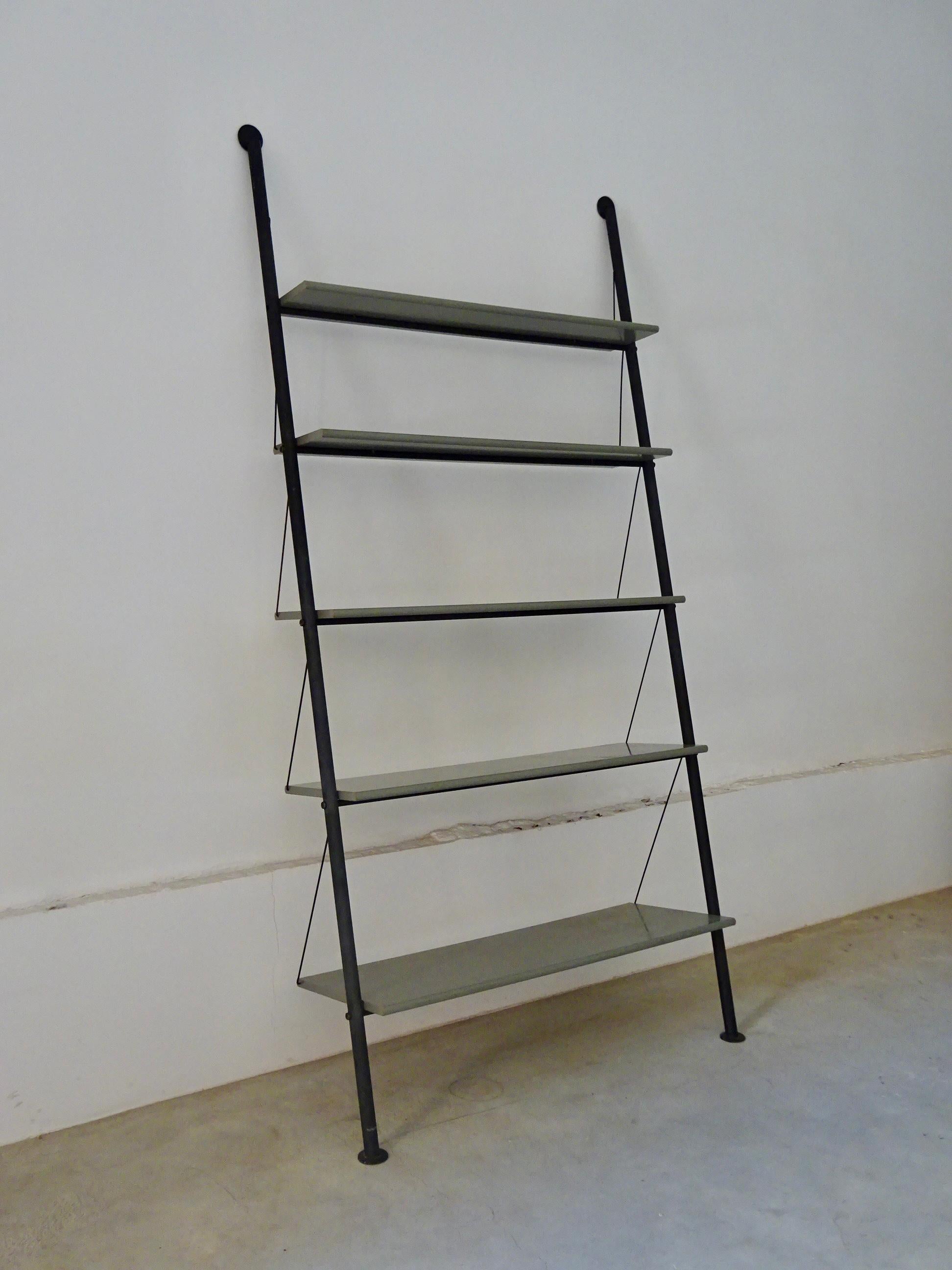 “John Ild” shelf, model in 1977, designed by Philippe Starck, produced by Disform in 1982. The structure is composed of two black metal tube uprights that can be placed against a wall and that support five grey trays. Wear is consistent with its age.