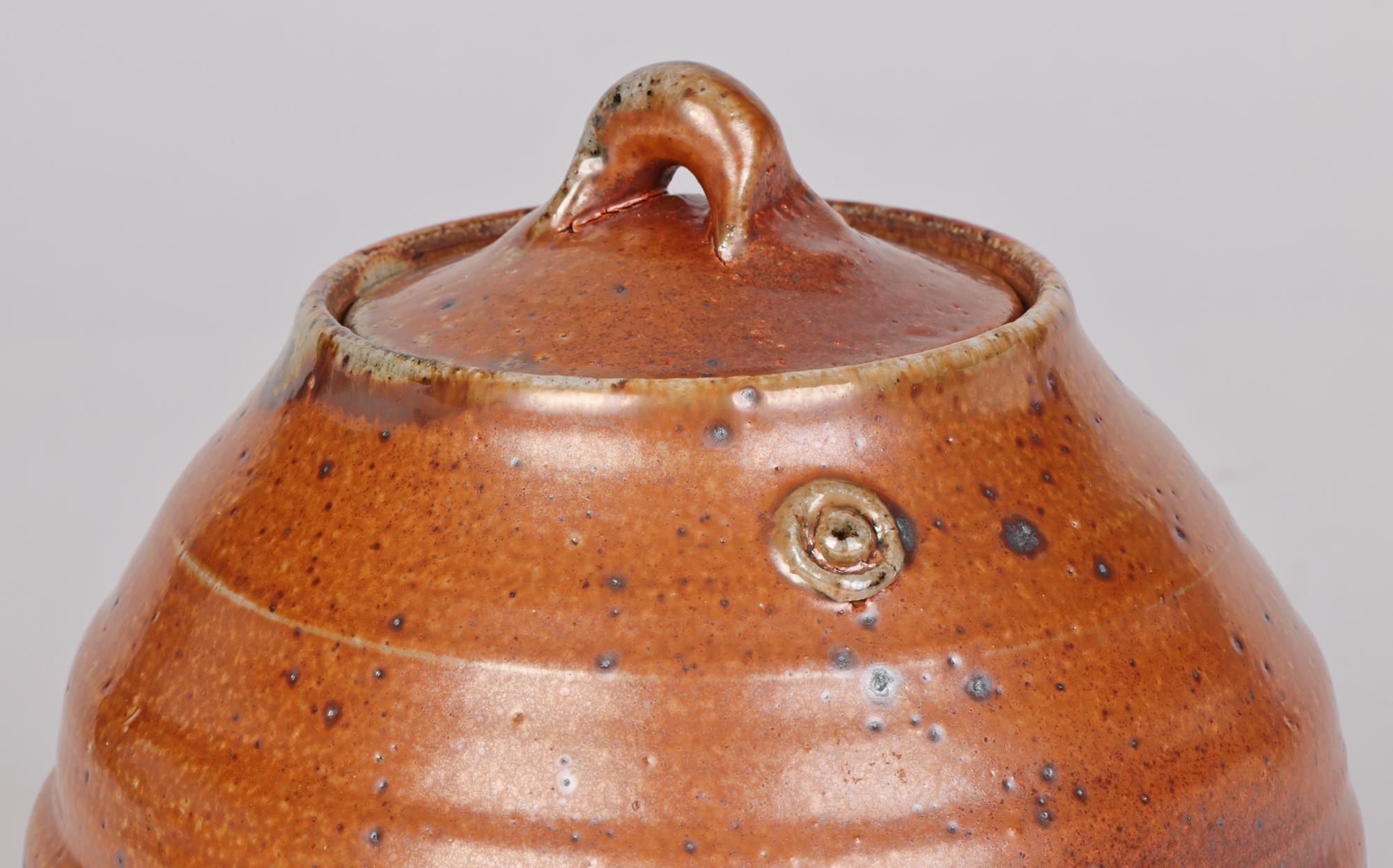 An impressive and stylish studio pottery lidded vessel decorated in brown salt glazes by renowned British potter John Jelfs (British, b.1946) and made at the Cotswold Pottery and believed to date from the 20th century. The jar shaped vessel is hand