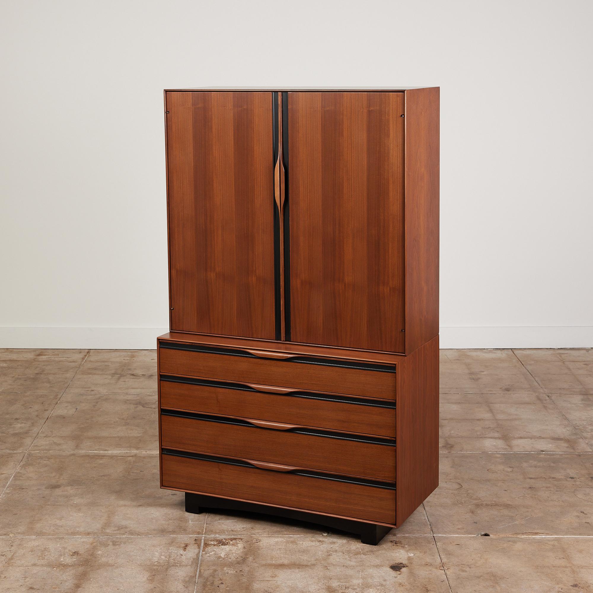 Walnut armoire by John Kapel for Glenn of California, c.1960s, USA. The piece features four drawers with sculpted handles and black laminate linear detailing. Three of the lower drawers are divided into compartments. Above the dressers drawers rests