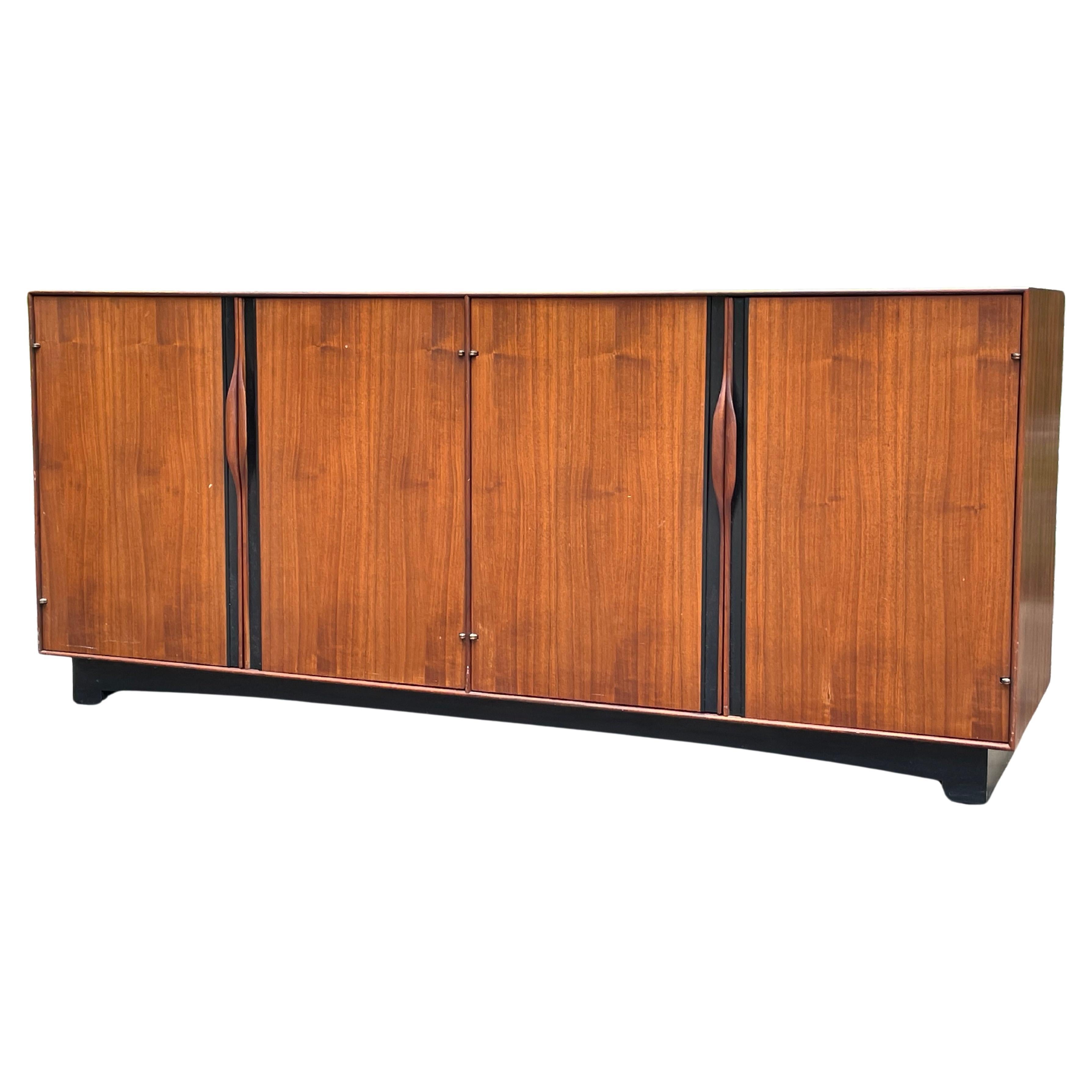 Mid-Century credenza designed by John Kapel for Glenn of California, circa 1960’s. Signed with tag in top drawer.

This John Kapel credenza features the designer’s signature sculpted walnut handles. The walnut credenza interior features two shelved
