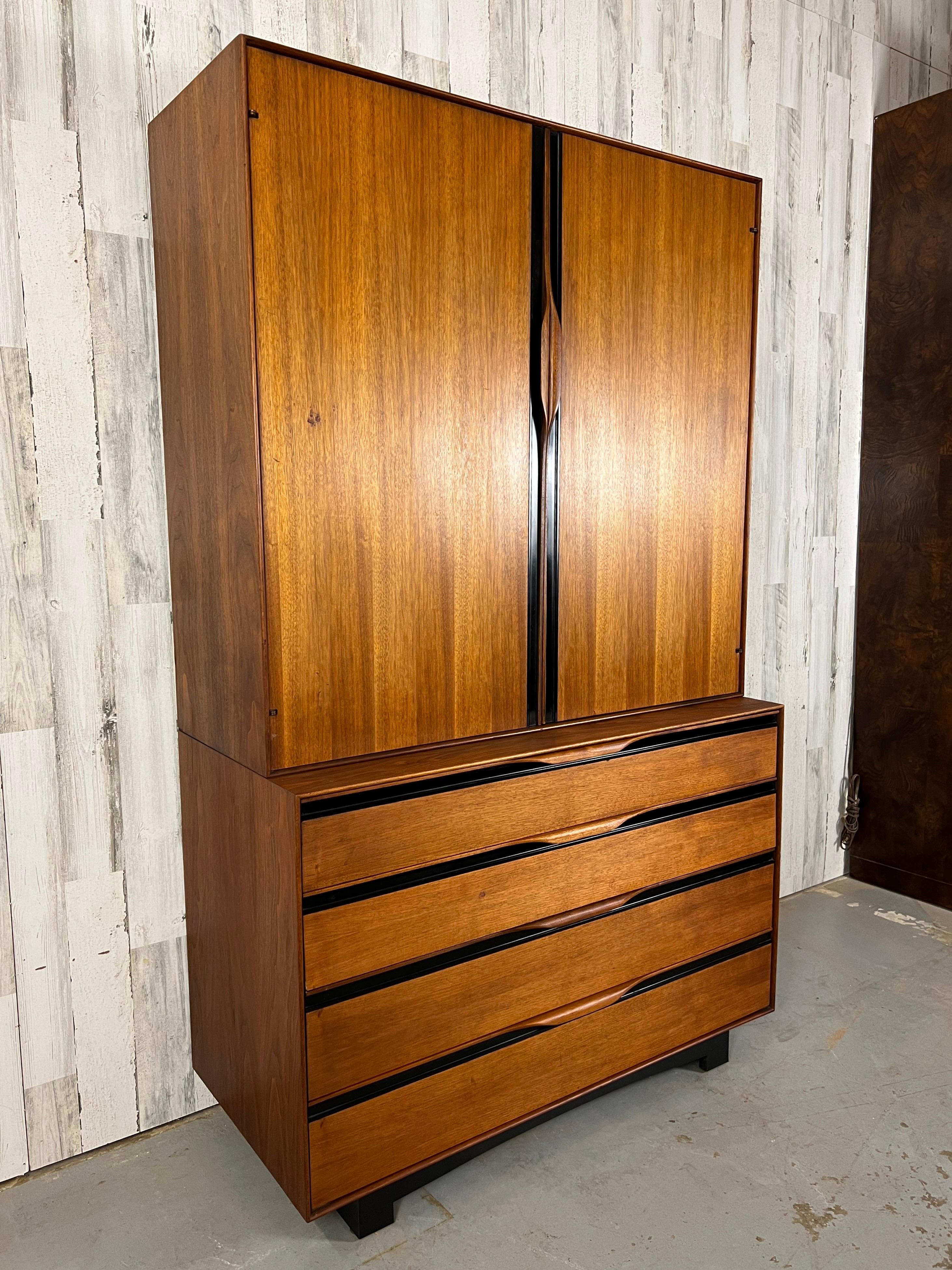 Original condition John Kapel Designed tall wardrobe with adjustable shelves in the upper cabinet and central mirror concealing two more shelves. Easy gliding drawers in the lower cabinet with vintage psychedelic shelf paper.
 