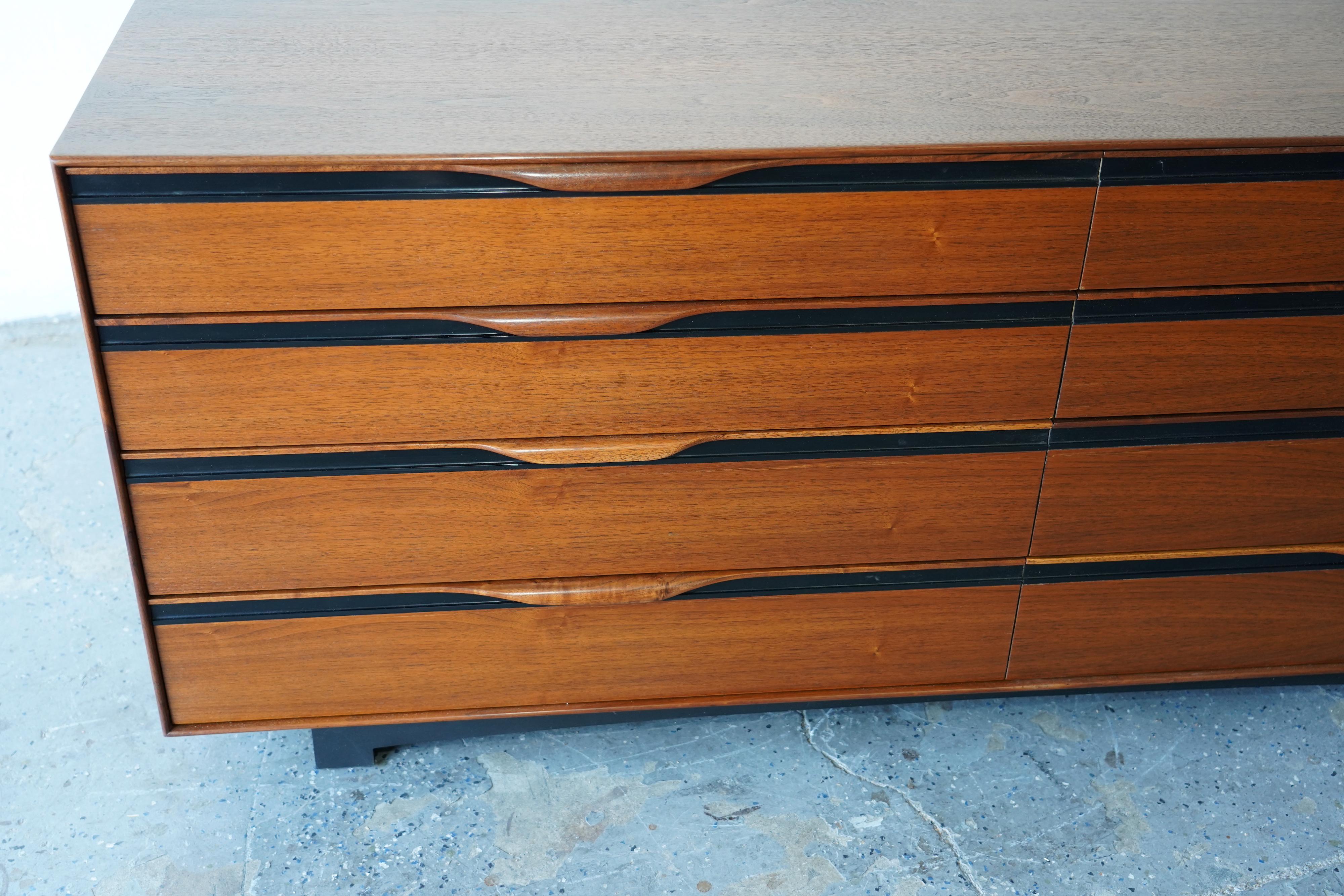 This distinguished by John Kapel for Glenn of California dresser features a streamlined design with exceptional craftsmanship and premium materials. Notable elements include elegantly sculpted handles, refined black trim, and a subtly curved