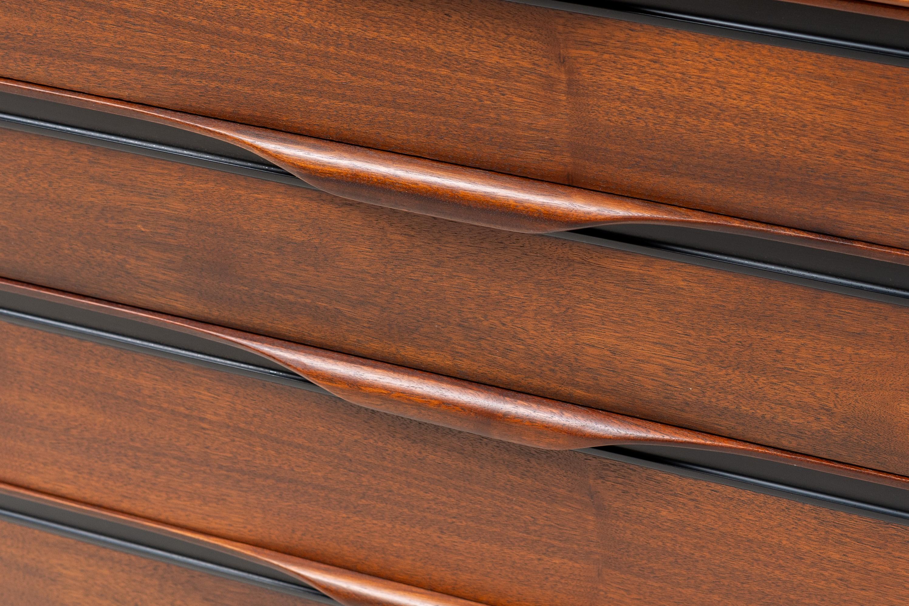 USA, ca. 1960s. A handsome two-piece gentleman’s chest or highboy by John Kapel for Glenn of California - retailed by John Stuart of NYC. Features walnut construction with a lower portion consisting of four wide storage drawers - each with original
