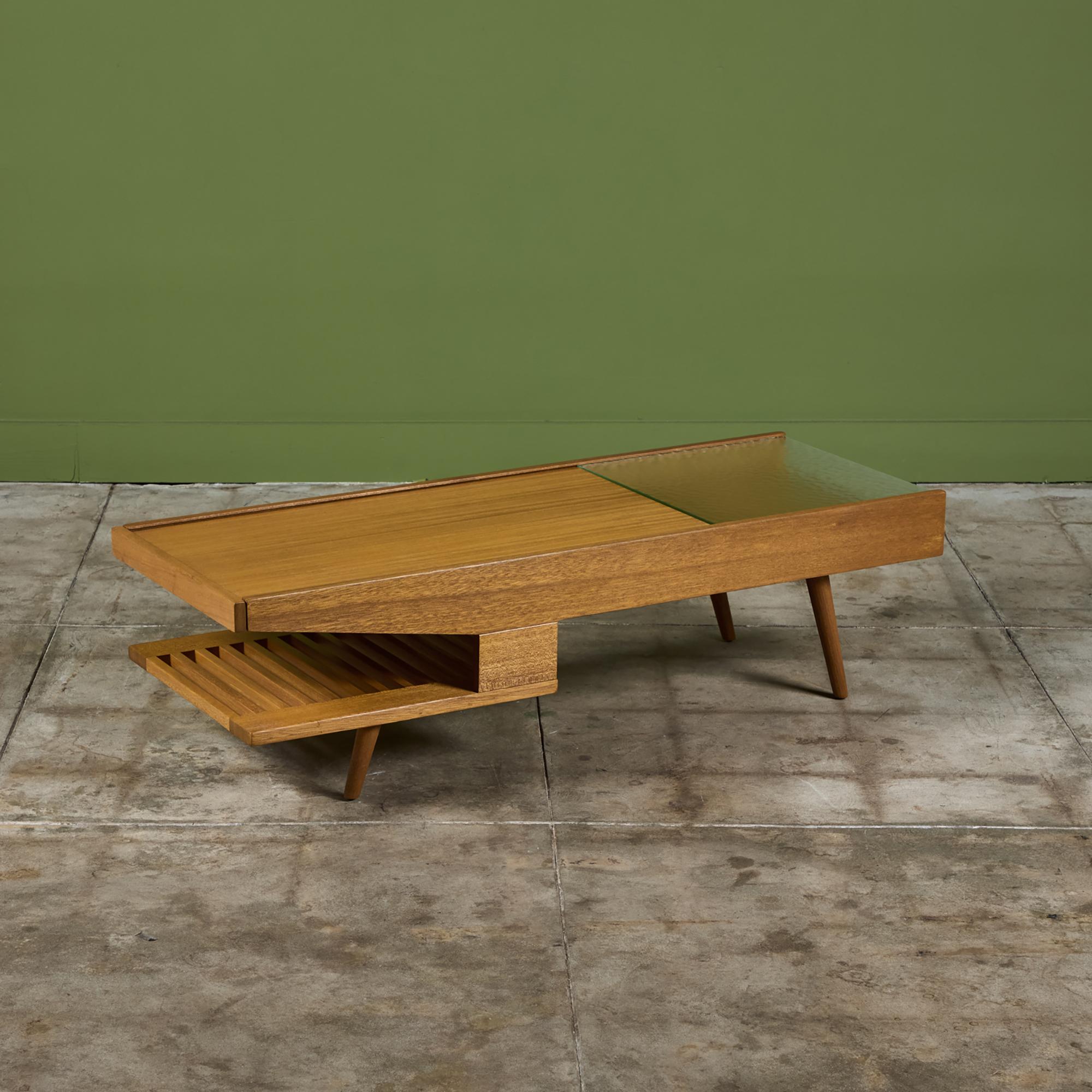 Rectangular coffee table by John Keal for Brown Saltman, c.1950s, USA. The table features a mix of textured glass and mahogany. The mahogany side of the table slides open to reveal hidden storage. The table also has two shelves, one under the glass