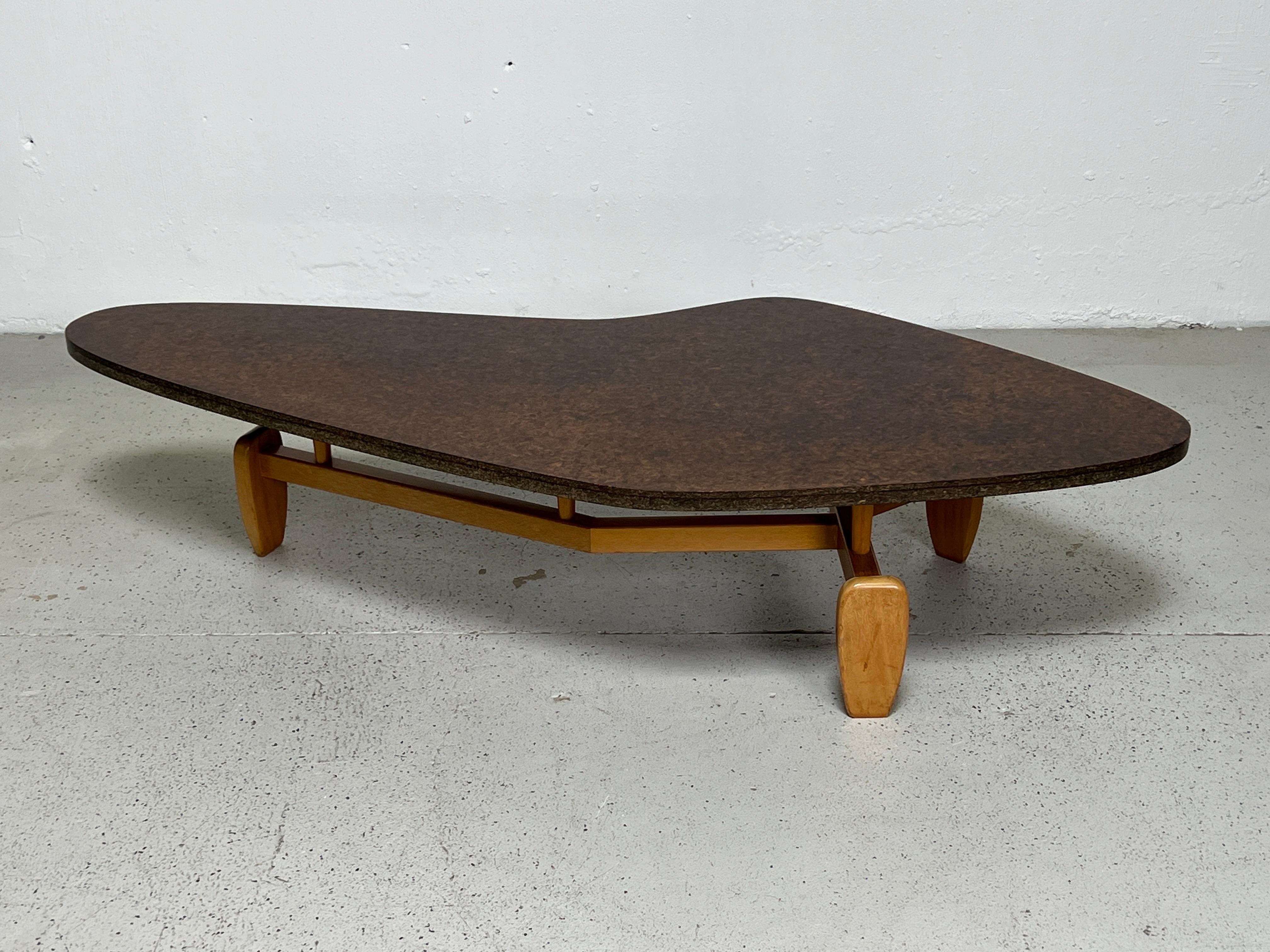 A boomerang shaped mahogany coffee table with lacquered cork / particle board top. Model 92 designed by John Keal for Brown Saltman.