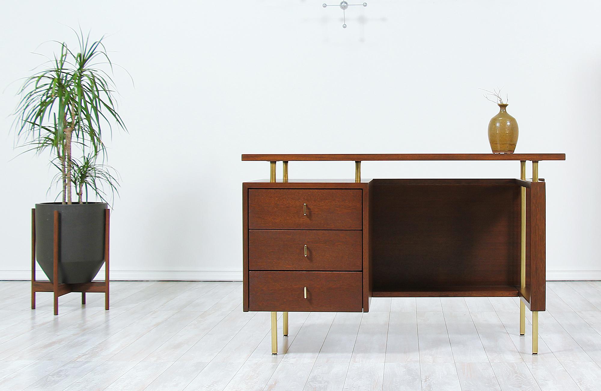 Stylish modern desk designed by John Keal for Brown Saltman in the United States circa 1950s. This exceptionally crafted desk features mahogany that has been stained in a warm walnut tone. The caned back adds an attractive element, allowing it to be