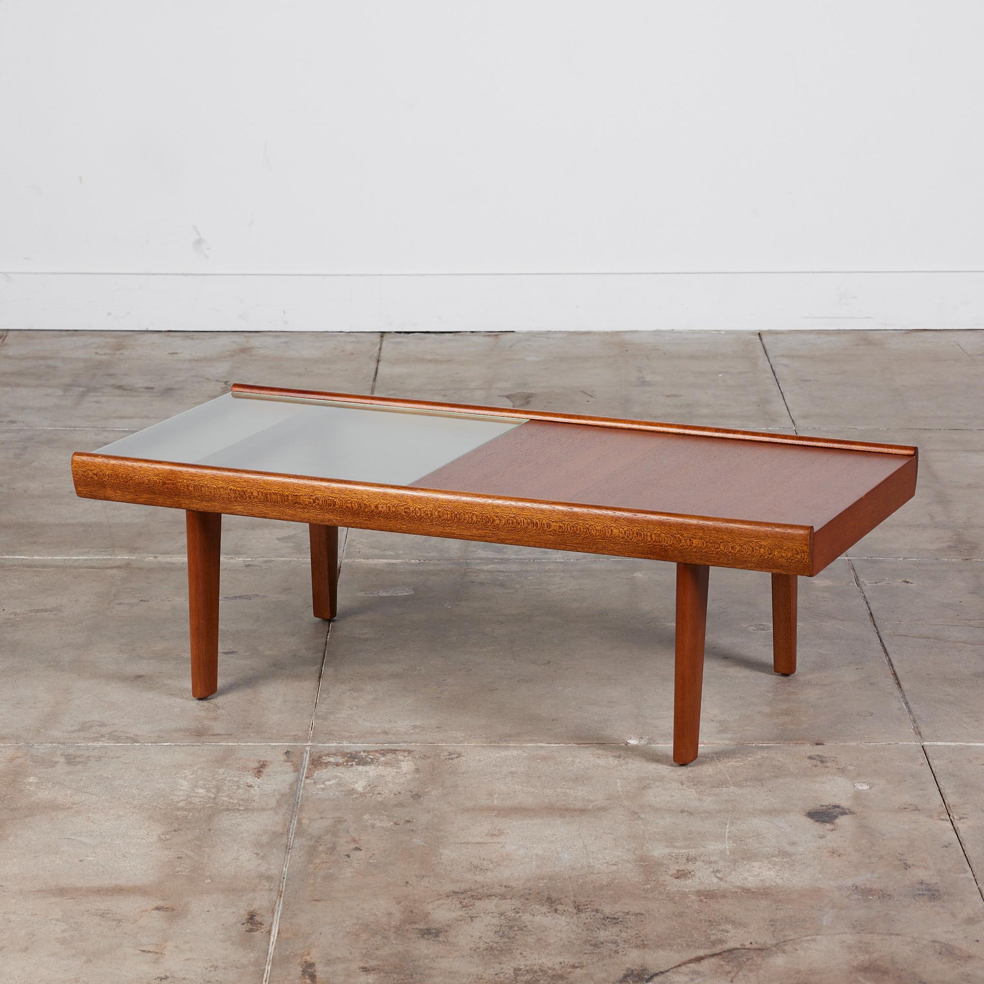 Rectangular coffee table by John Keal for Brown Saltman, c.1950s, USA. The table features a mix of textured glass and mahogany. The mahogany side of the table slides open to reveal hidden storage. The table rests on tapered dowel